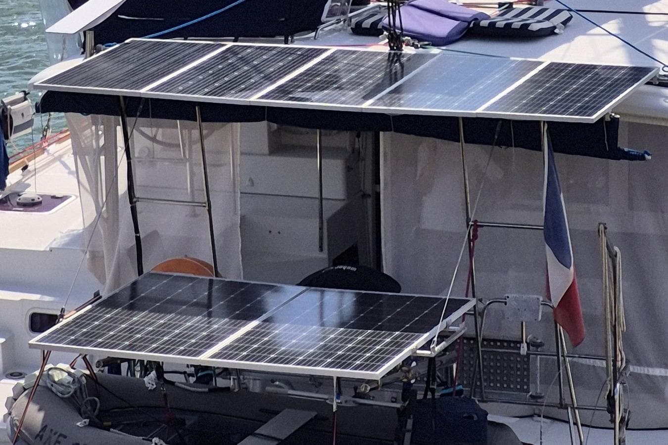 2017 Lagoon 400 S2 catamaran with solar panels and a flag, docked at a marina.