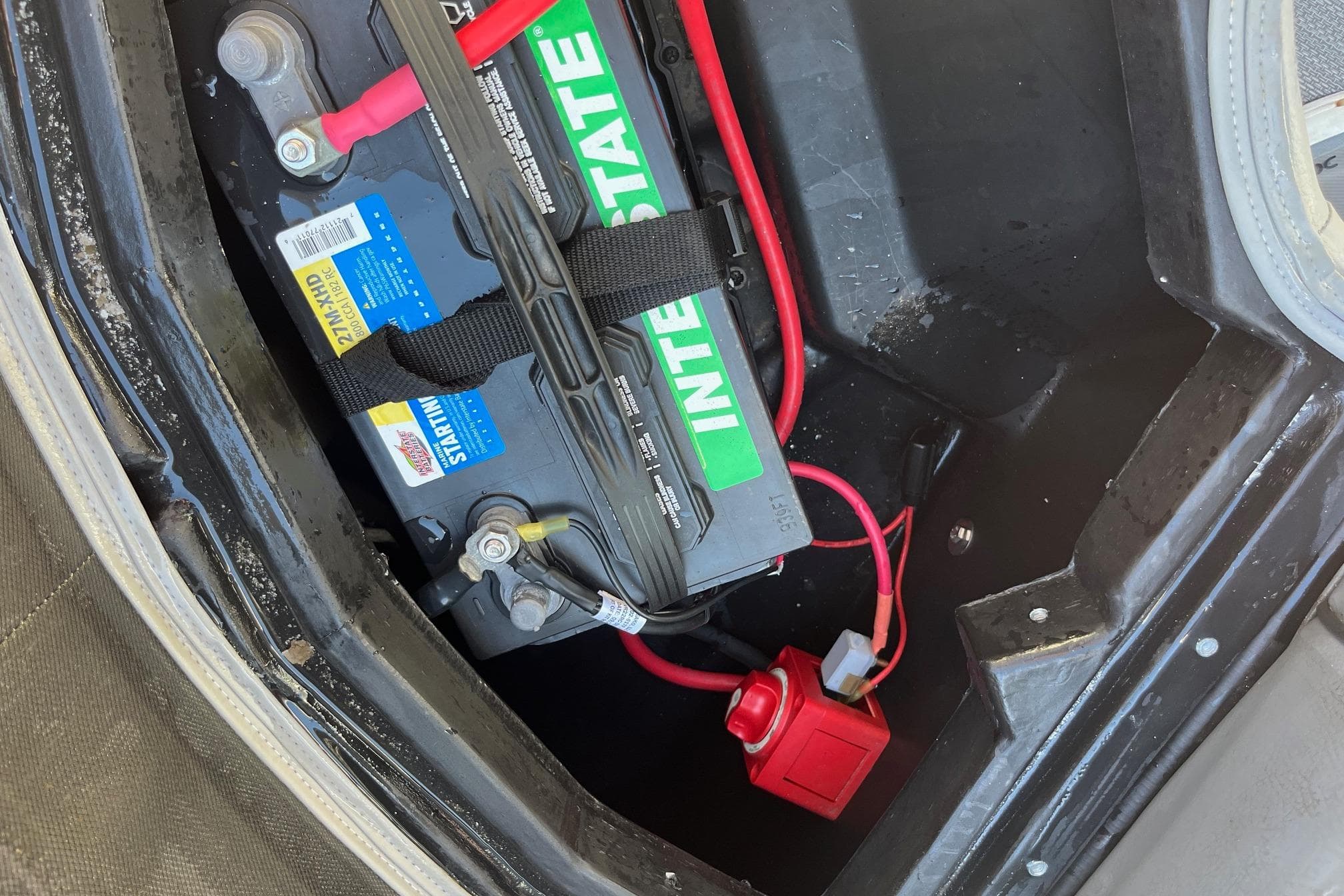 Battery compartment of 2023 Veranda Relax VR22RC with Interstate battery and red wiring.