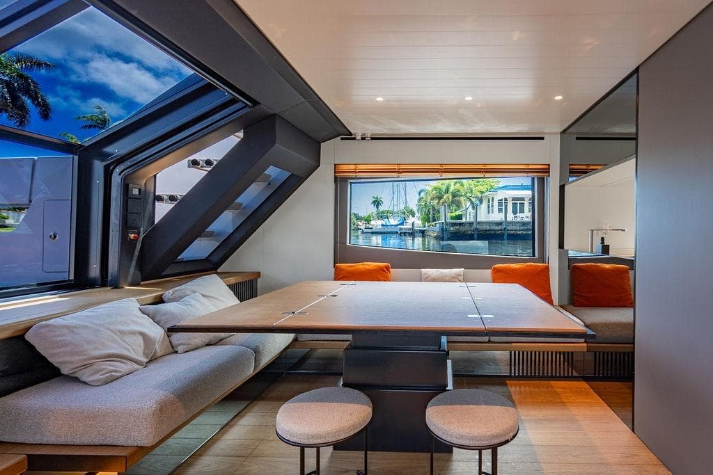 Luxurious interior of 2023 Bluegame BG 72 yacht with modern seating and large windows.