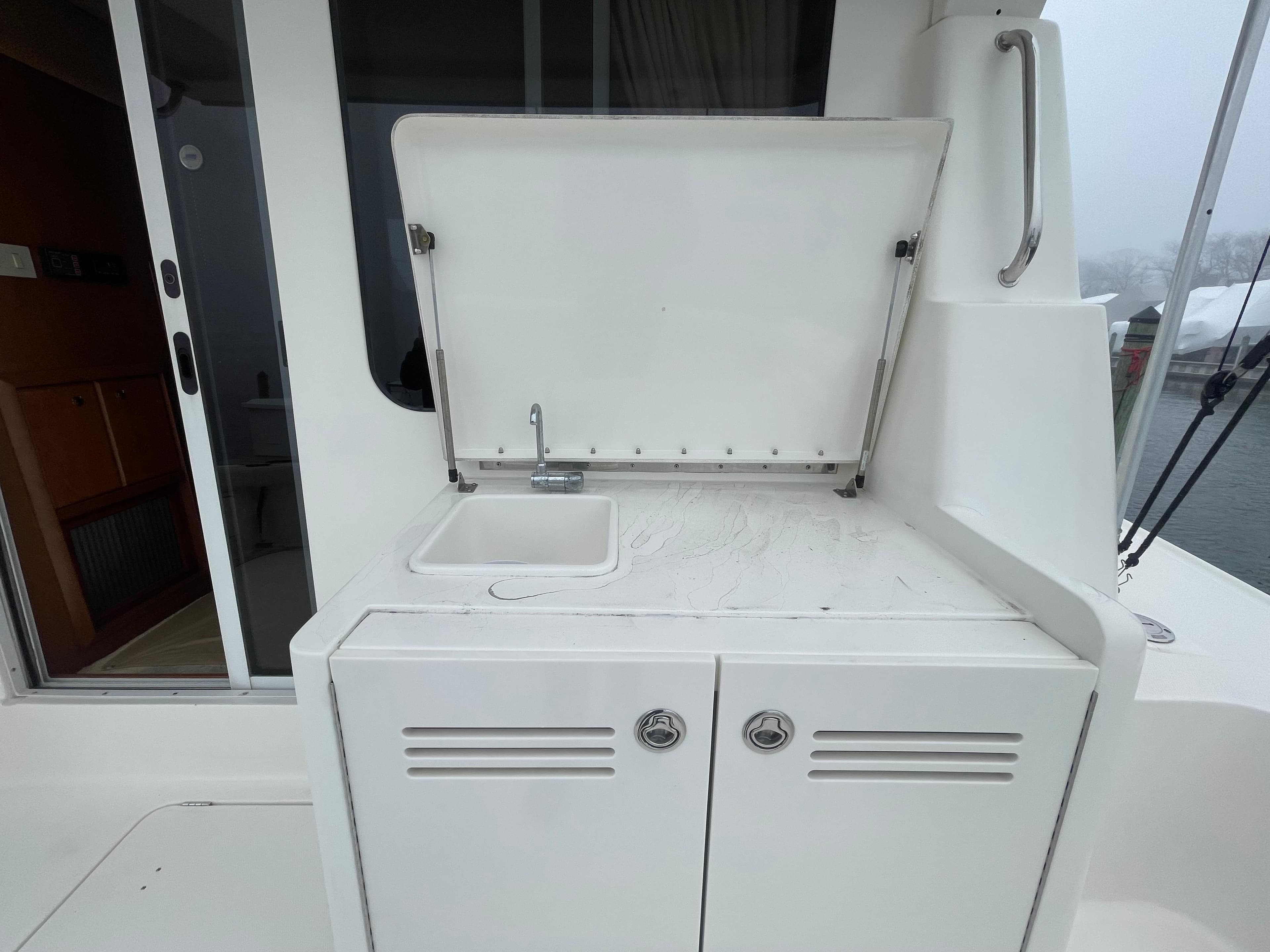 2006 Silverton 42 Convertible yacht sink and storage area on deck.