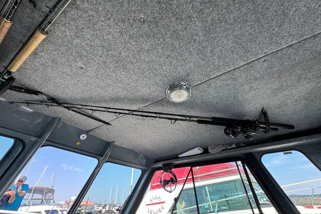 Interior of 2023 Boulton VOYAGER PRO boat with fishing rods on ceiling.