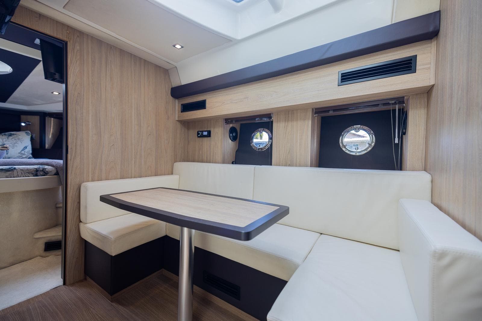 Luxurious interior of 2014 Cranchi M 44 HT yacht with elegant seating and porthole windows.