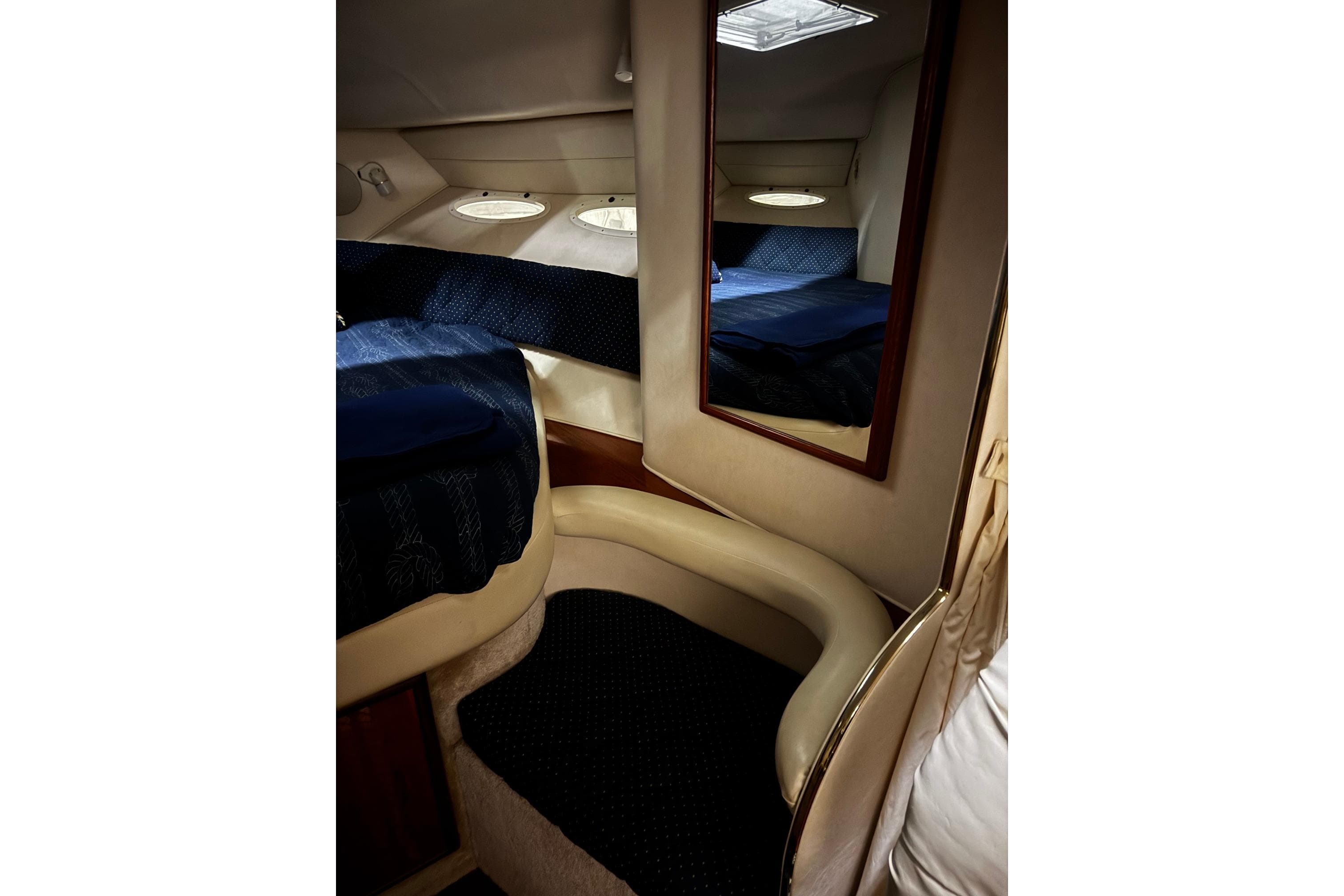 Interior cabin of 1999 Sea Ray 340 Sundancer with cozy seating and mirror.