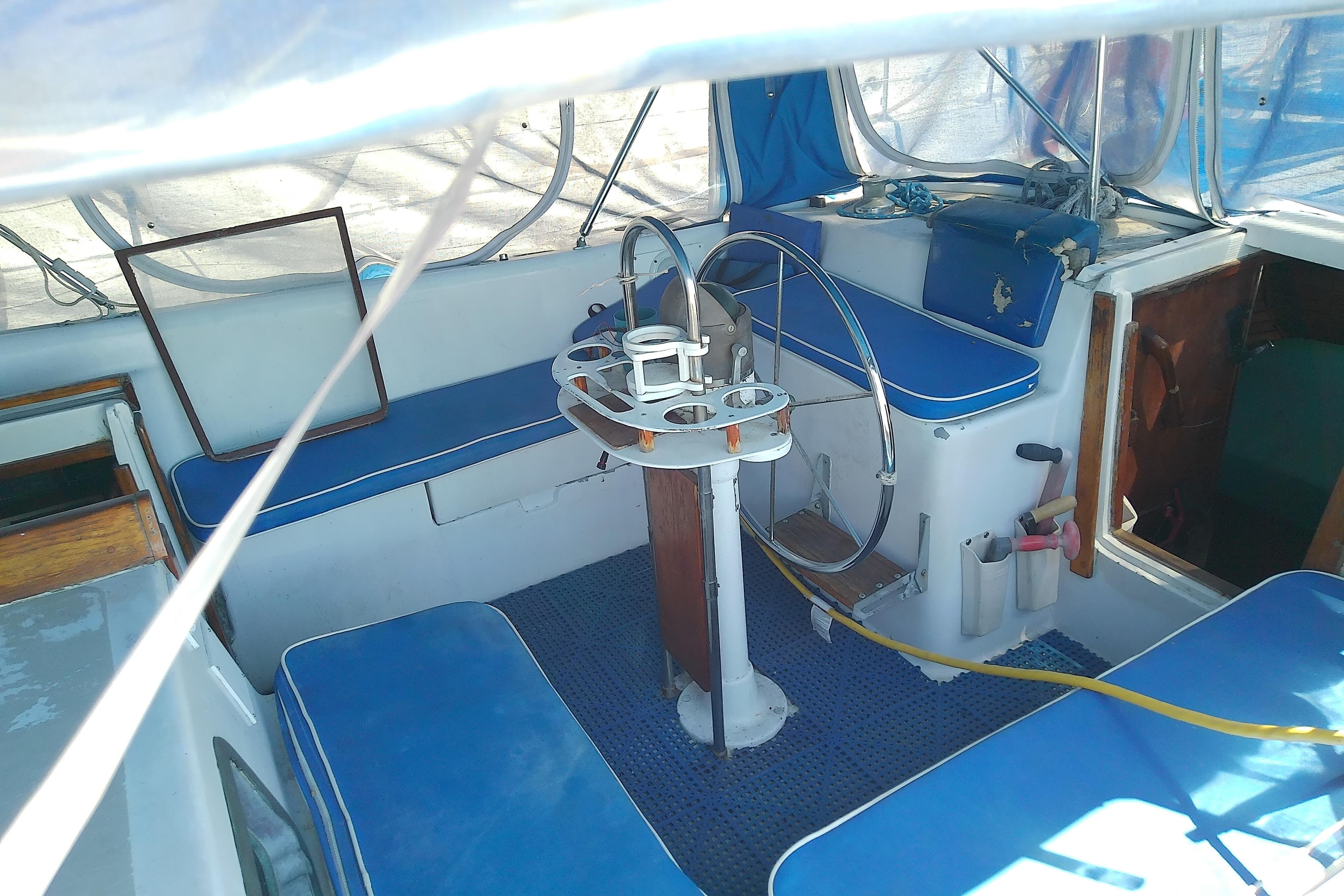 1972 Morgan Out Island 41 sailboat cockpit with blue seating and steering wheel.