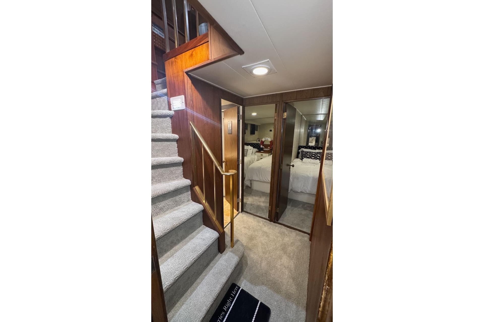 Interior of 1974 Burger 67 Motor Yacht with carpeted stairs and mirrored doors.