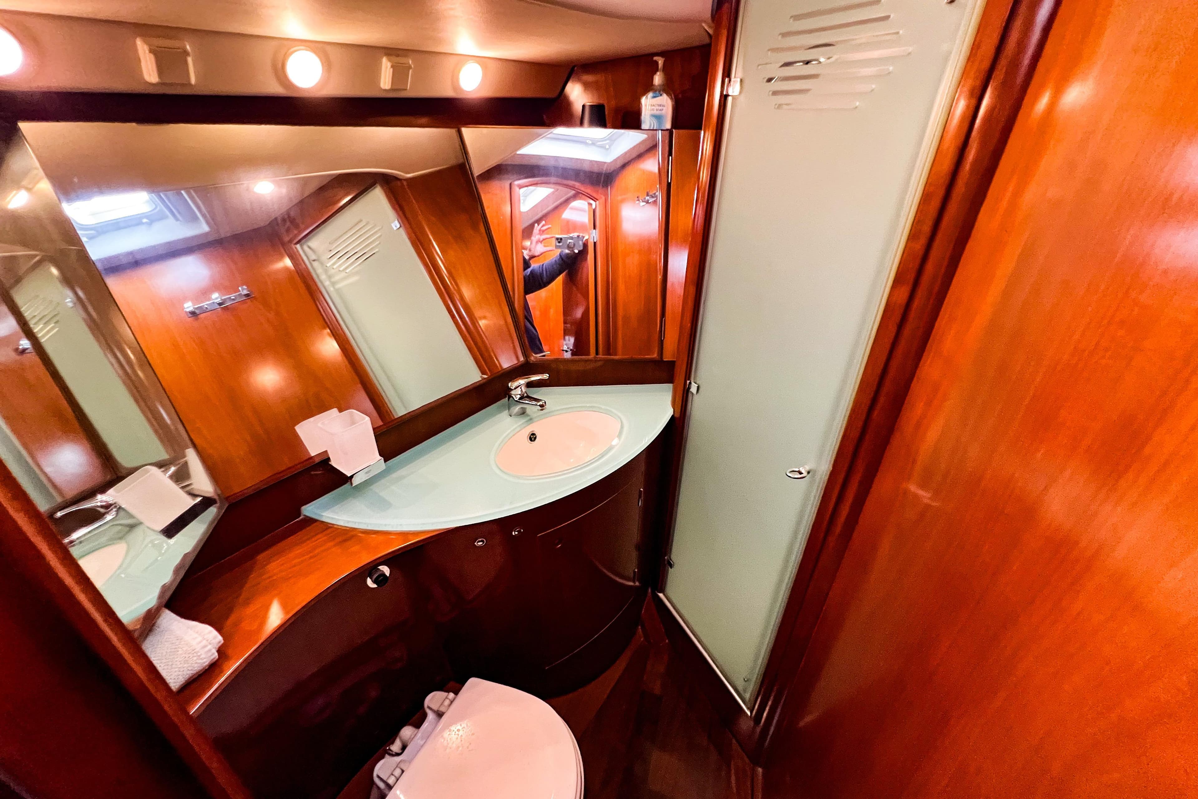 Luxurious bathroom in a 2004 Beneteau 57 yacht with wood finish and modern fixtures.