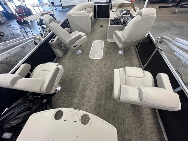 2017 Harris Cruiser 200 pontoon boat interior with beige seating and steering console.
