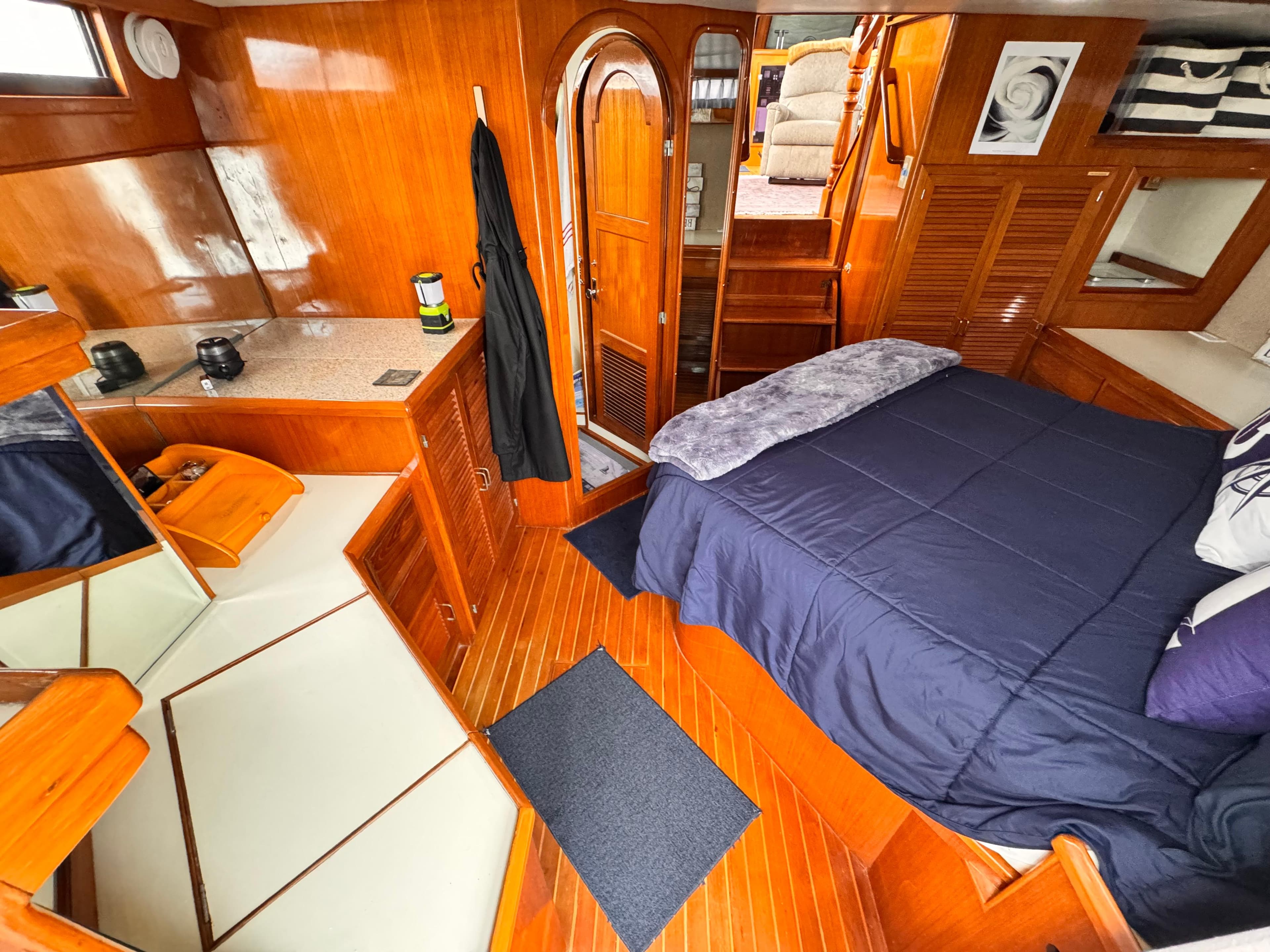 Luxurious 1988 Overseas PT52 Cockpit Motoryacht interior with wood finish and cozy bedroom.