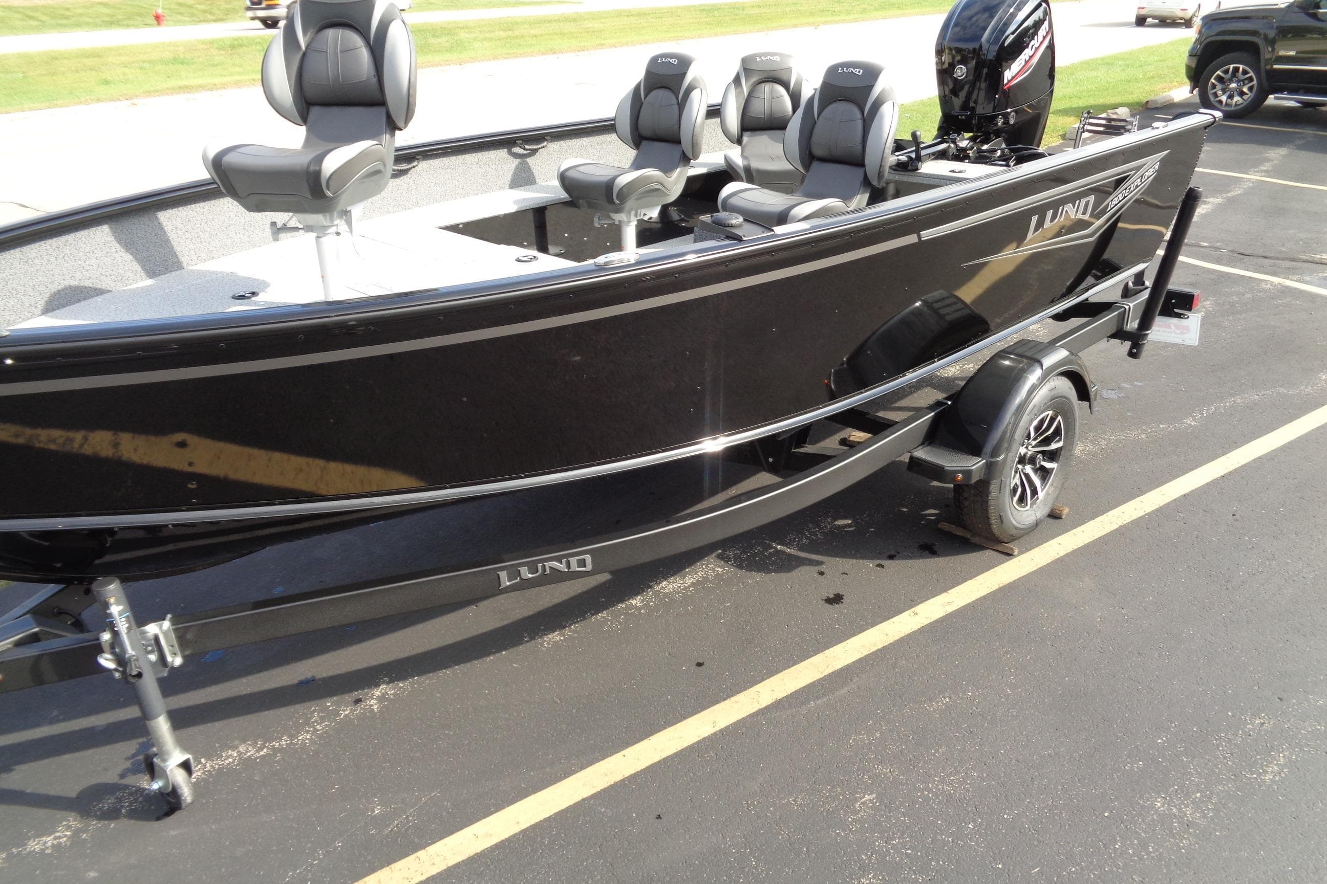 2026 Lund 1800 Explorer Tiller boat on trailer, black exterior, parked outdoors.