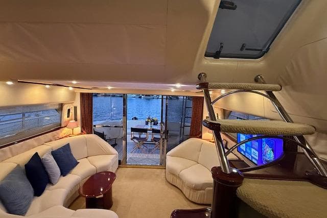 Luxurious 1996 Princess yacht interior with elegant seating, staircase, and waterfront view.