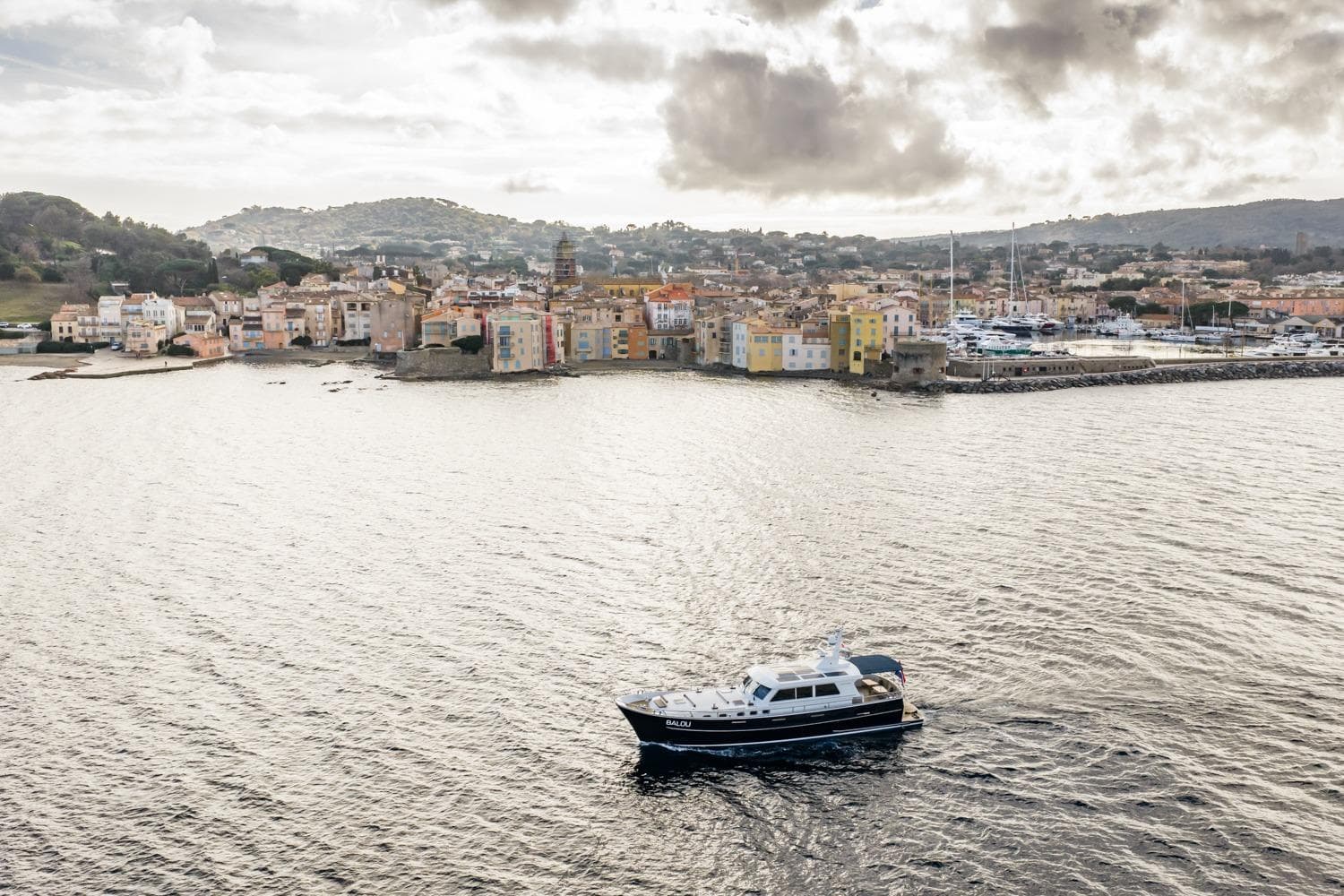 Sturier 620 OC yacht cruising near a picturesque coastal town, 2013 model.