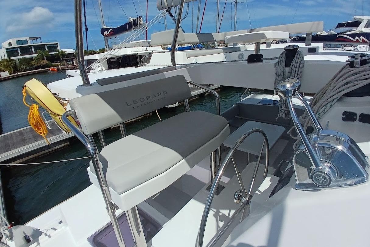 2022 Leopard 42 catamaran helm station with steering wheel and seating at marina.