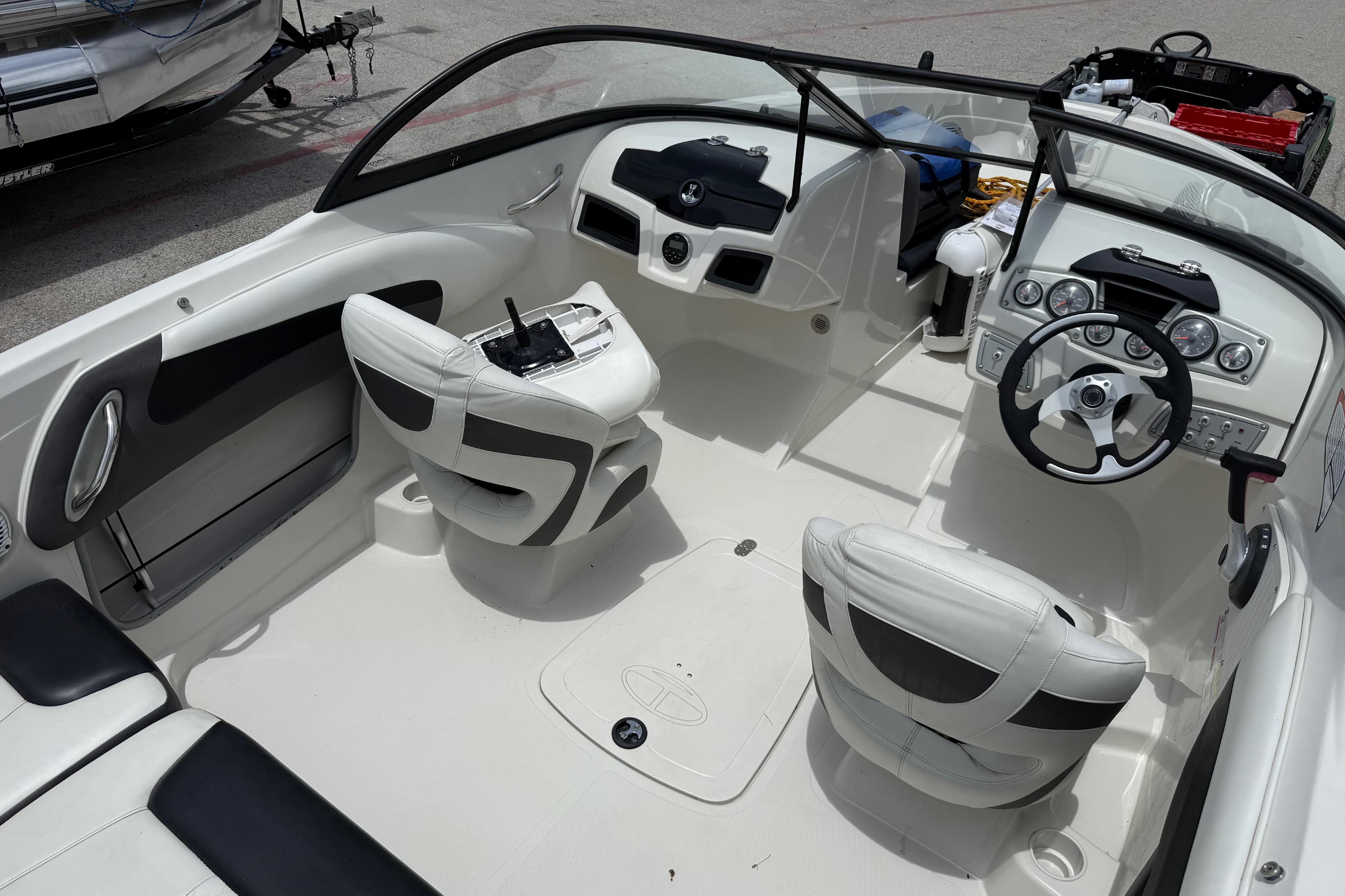 Interior of a 2016 Tahoe 500 TF boat, featuring sleek white seating and modern dashboard controls.