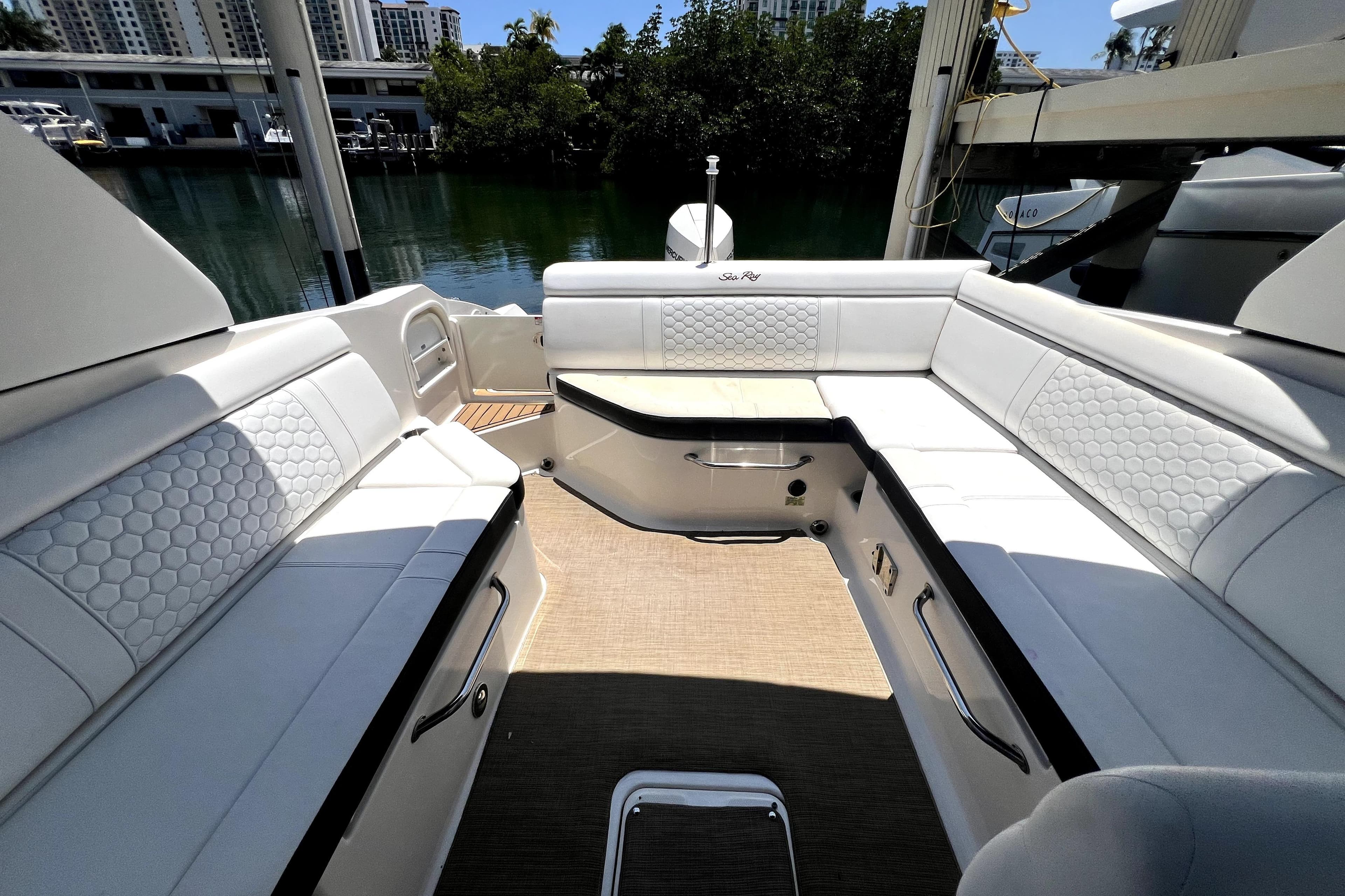 Luxurious interior of 2019 Sea Ray SDX 270 Outboard boat with white seating and scenic marina view.
