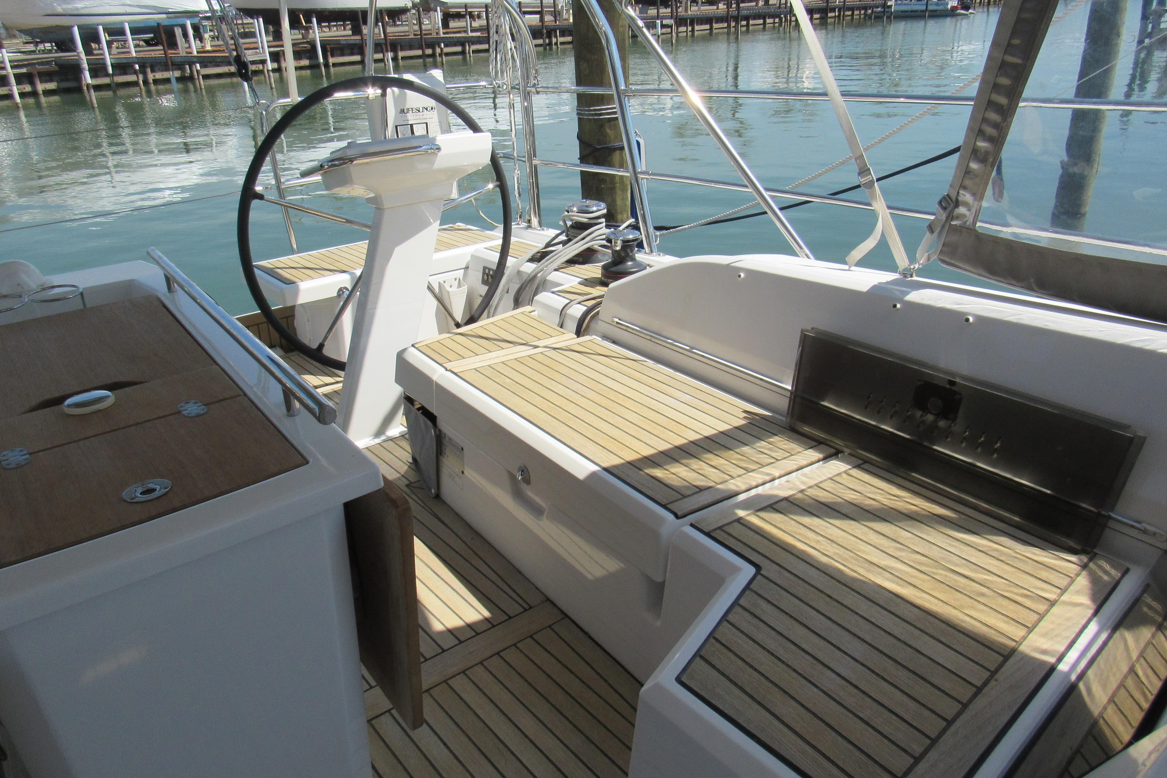 Cockpit of 2020 Beneteau Oceanis 46.1 yacht with wooden deck and steering wheel.