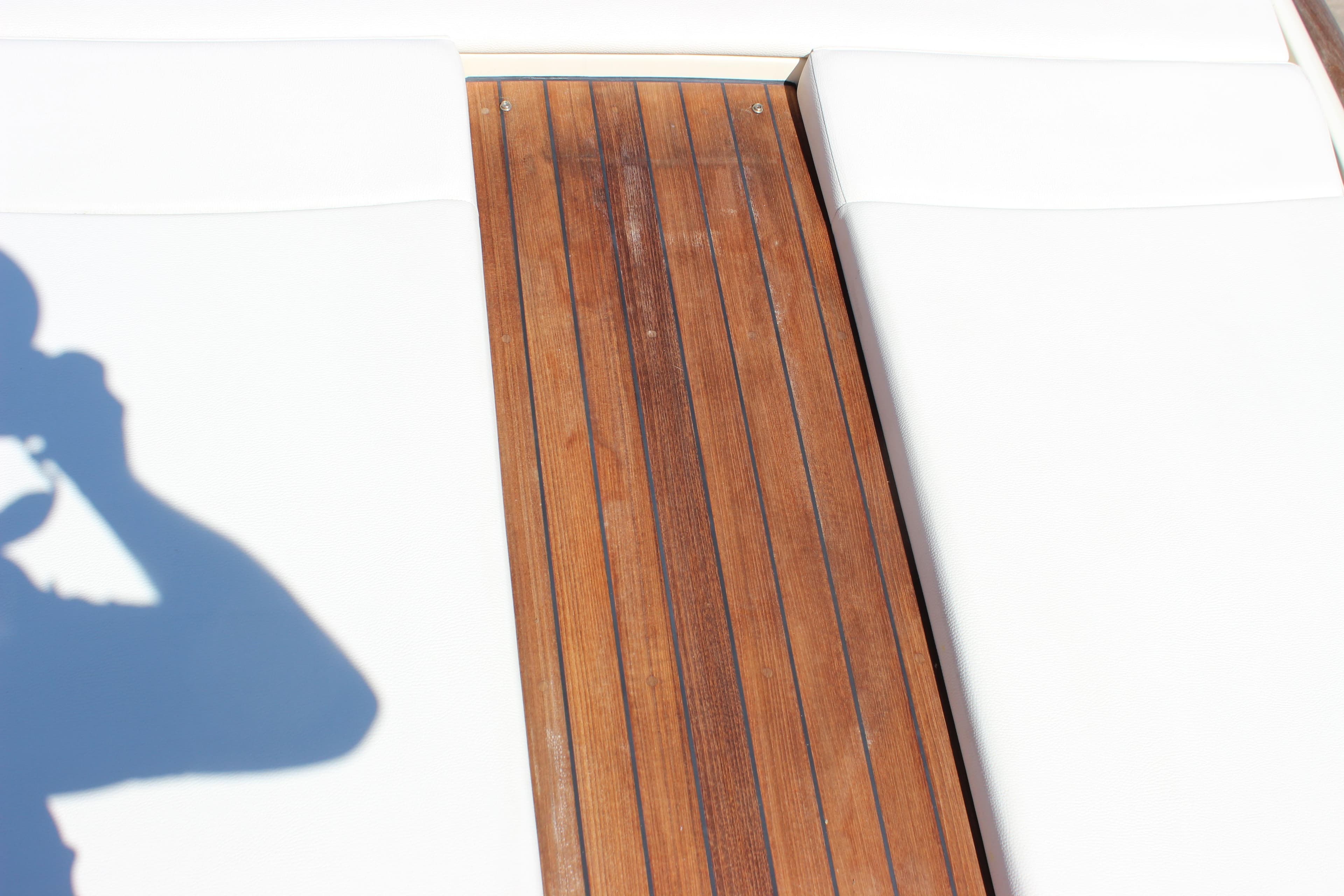 2024 Chris-Craft Launch 27 boat deck with wooden finish and white seating.