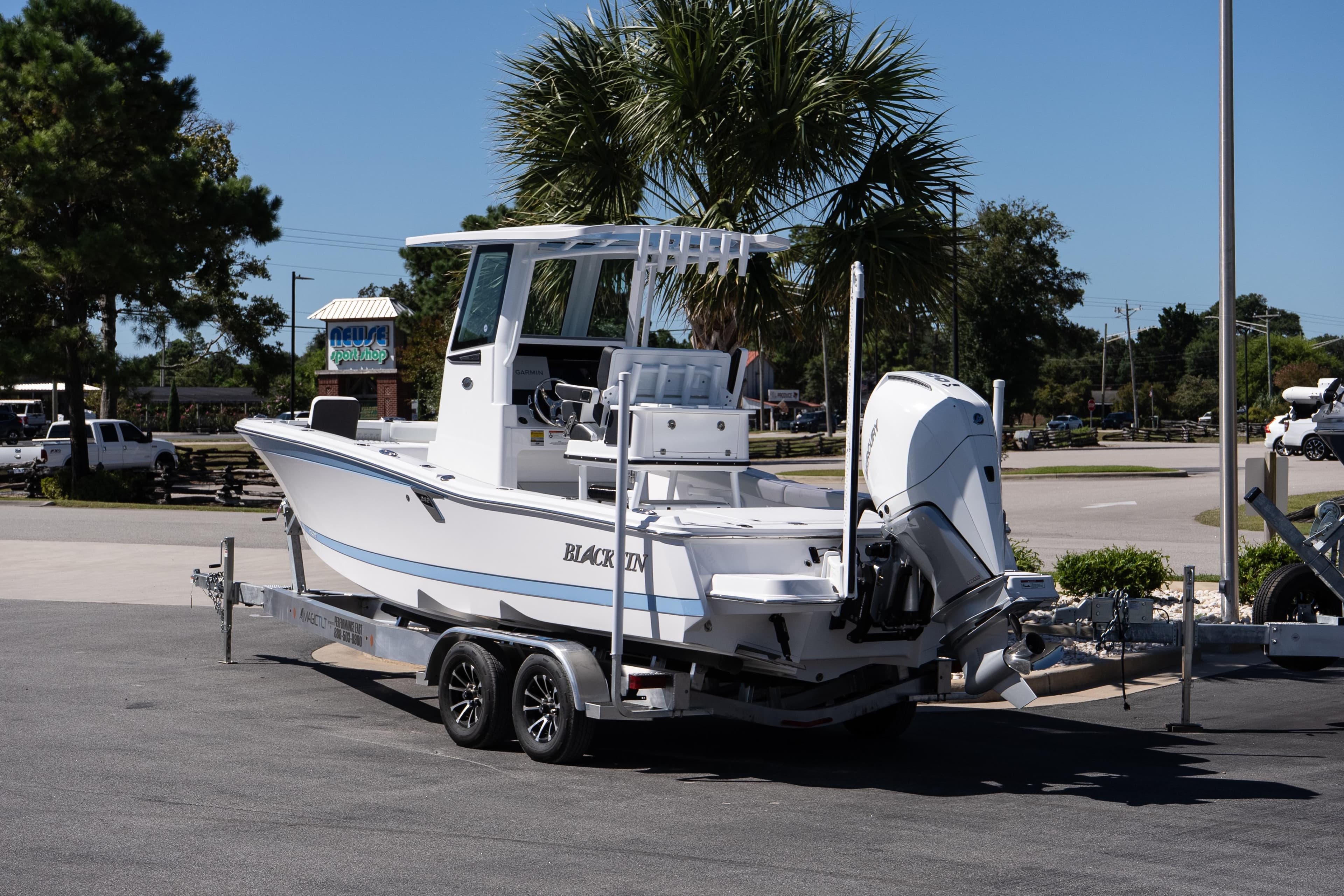 2026 Blackfin 242 HB boat on trailer, parked outdoors under clear blue sky.