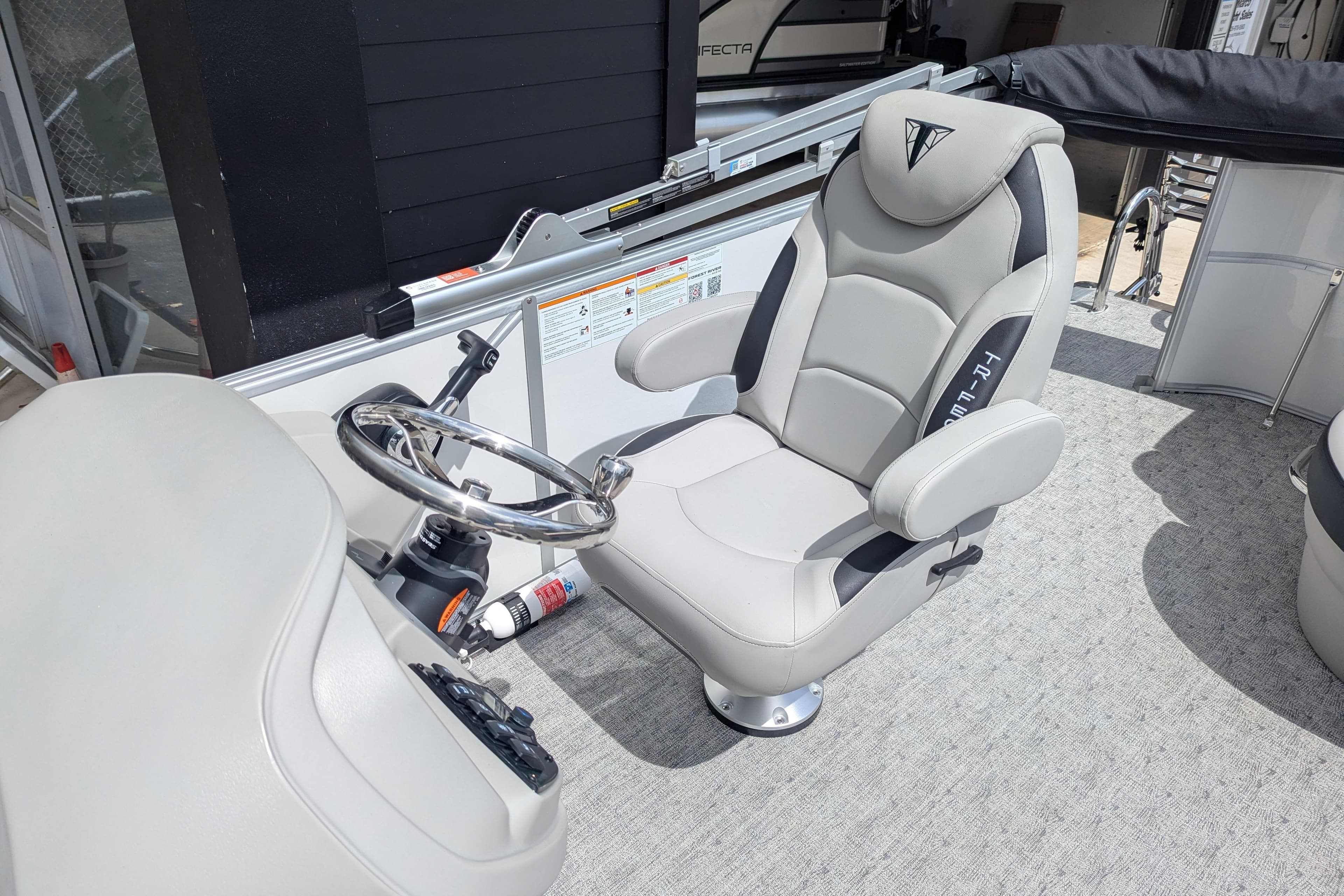 Captain's chair and steering wheel of 2026 Trifecta 20CLE pontoon boat.