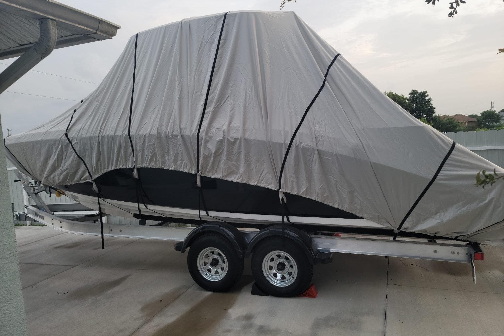 2022 Yamaha Boats 255 FSH Sport E covered on trailer in driveway.