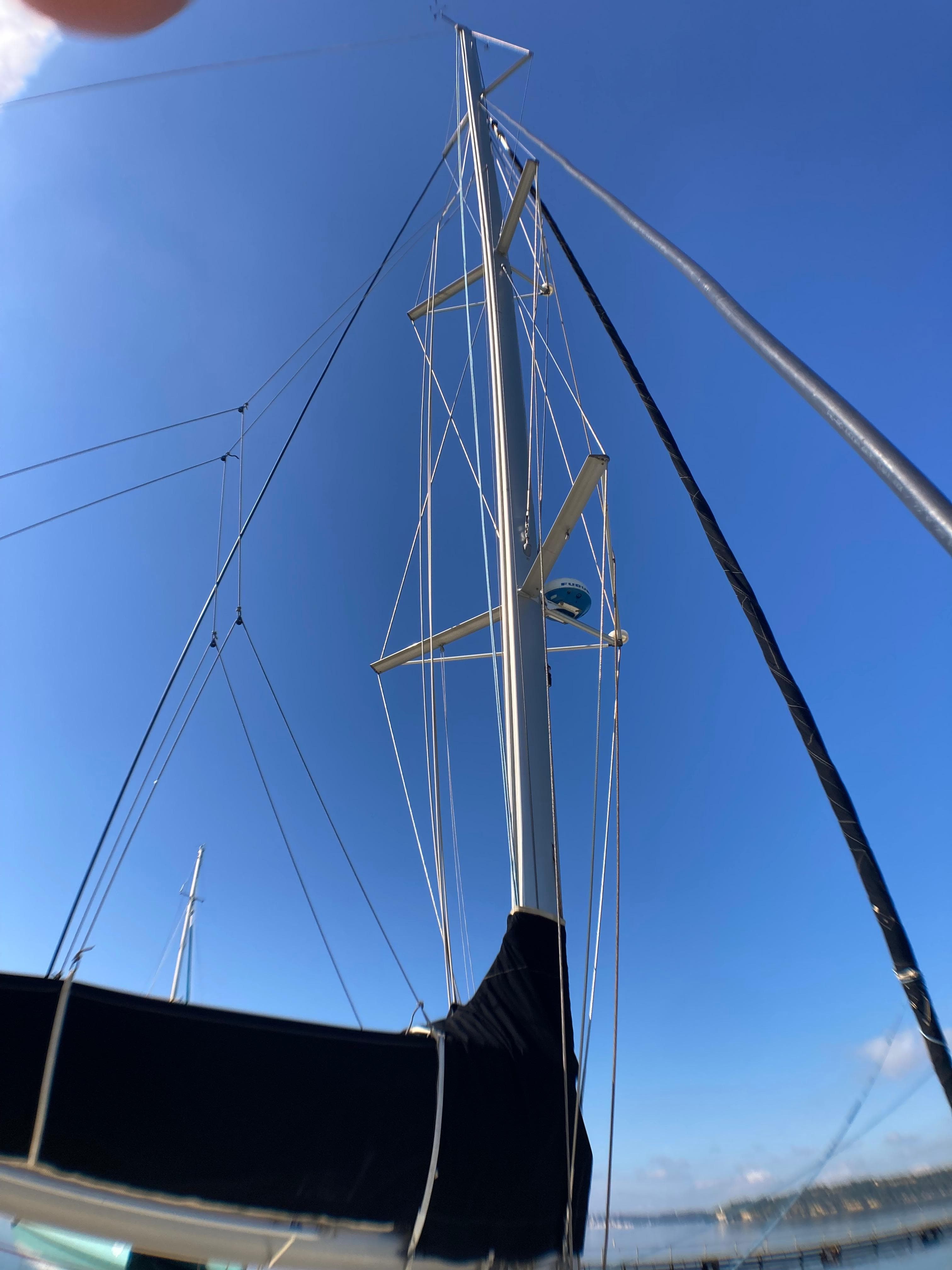 Custom catamaran mast against clear blue sky, 15 meters, year 2000.