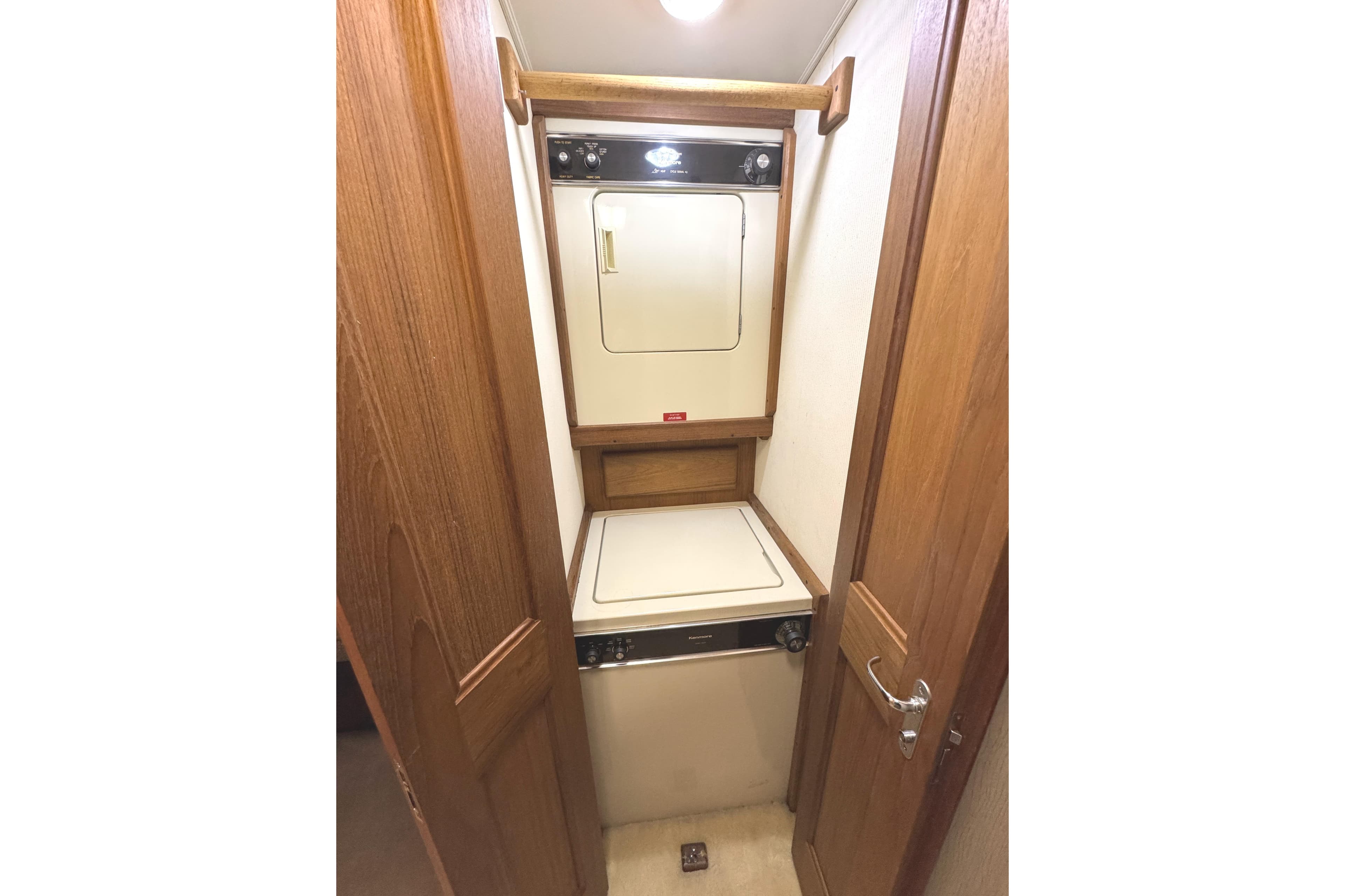 Laundry area in 1991 Viking 53 Convertible yacht with wood paneling and compact washer-dryer.