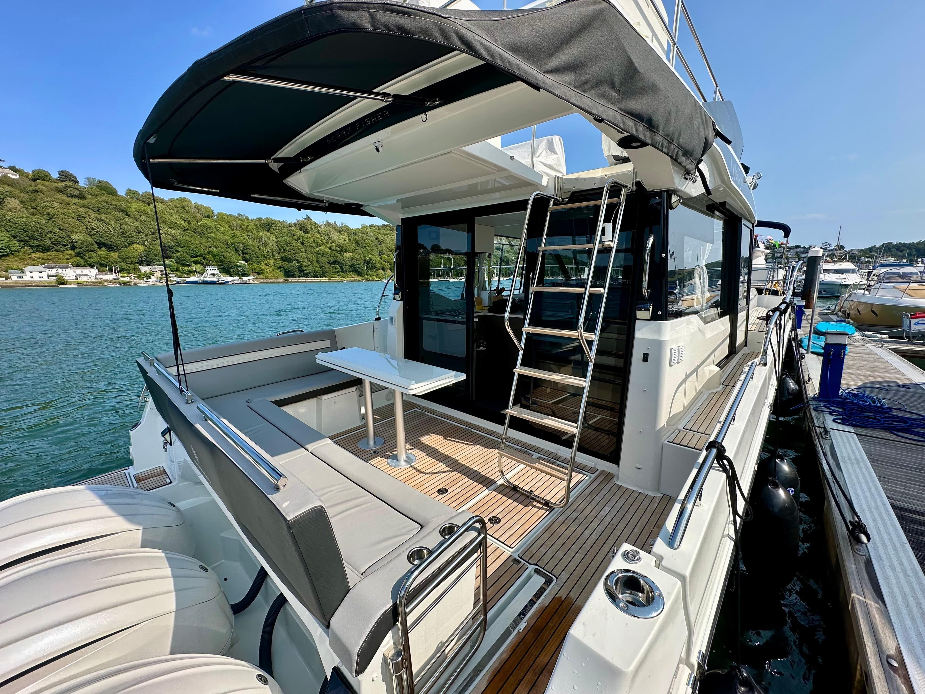 2024 Jeanneau Merry Fisher 1295 Flybridge yacht with spacious deck and seating area.