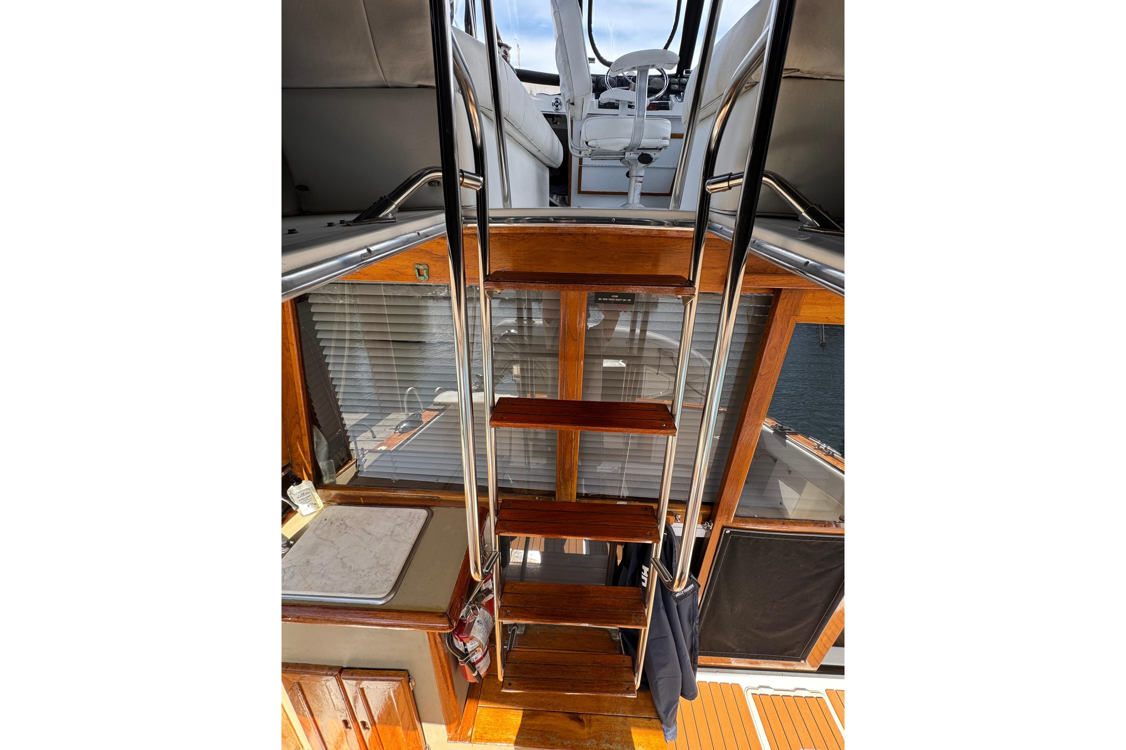 Staircase on 1995 Bayliner 3288 Motoryacht, leading to upper deck with seating.