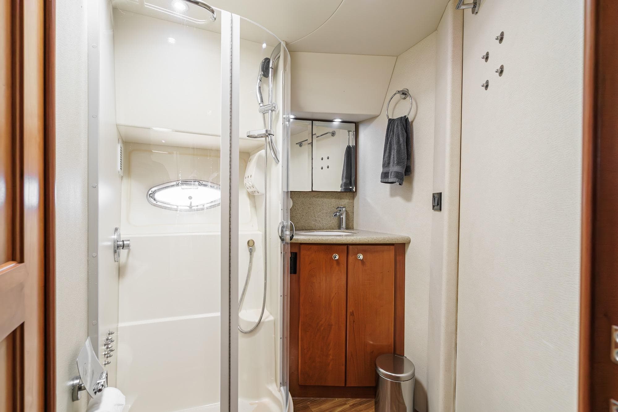 2007 Silverton Convertible yacht bathroom with shower, sink, and wooden cabinetry.