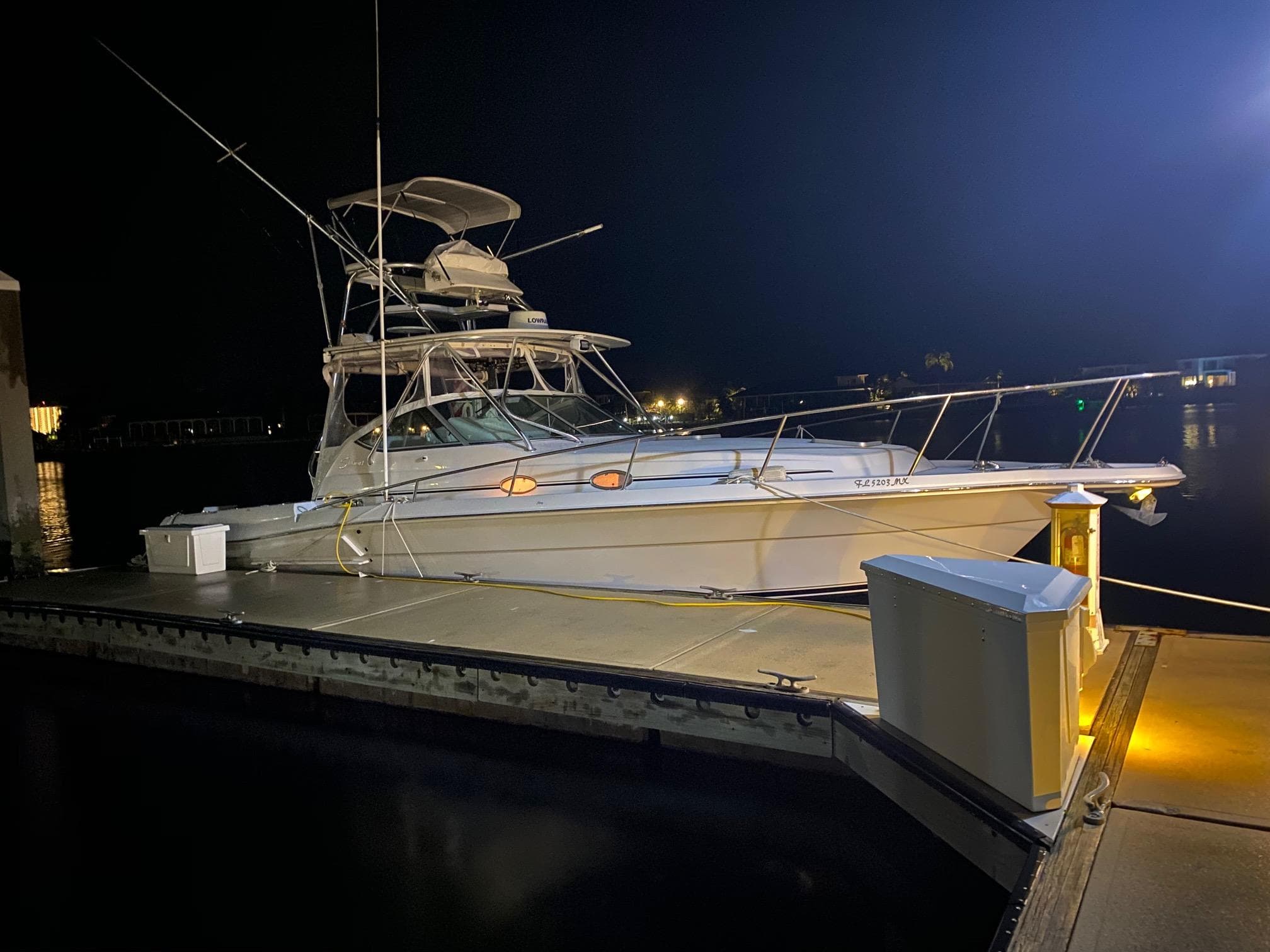 2005 Stamas 370 Express yacht docked at night, illuminated by dock lights.