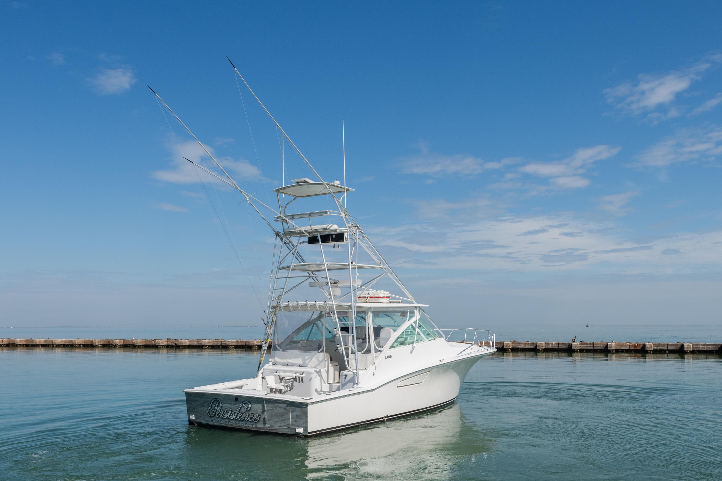 2004 Cabo 40 Express boat on calm water under a clear blue sky.
