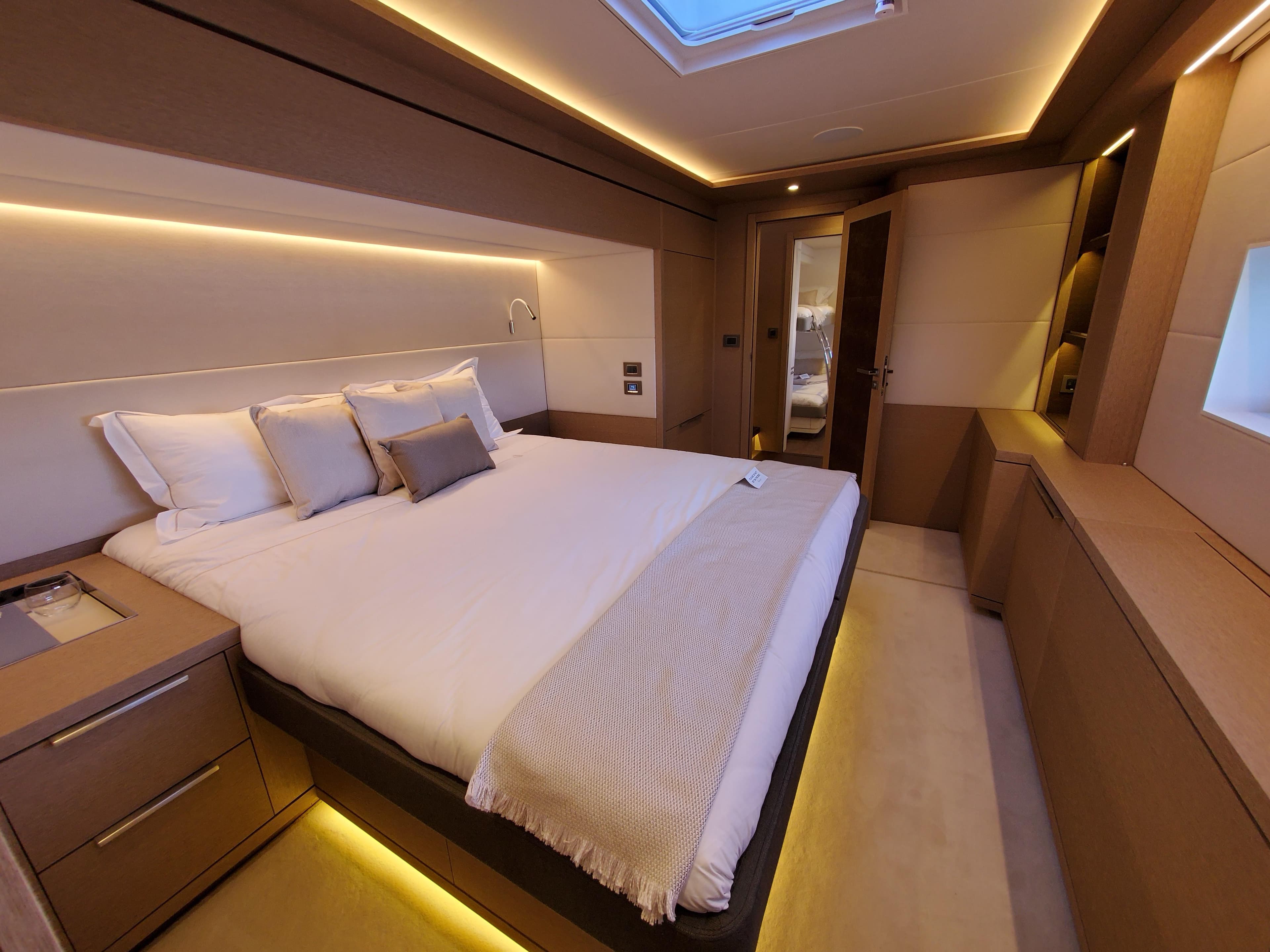 Luxurious bedroom interior of 2020 Lagoon SEVENTY 7 yacht with modern lighting and elegant design.