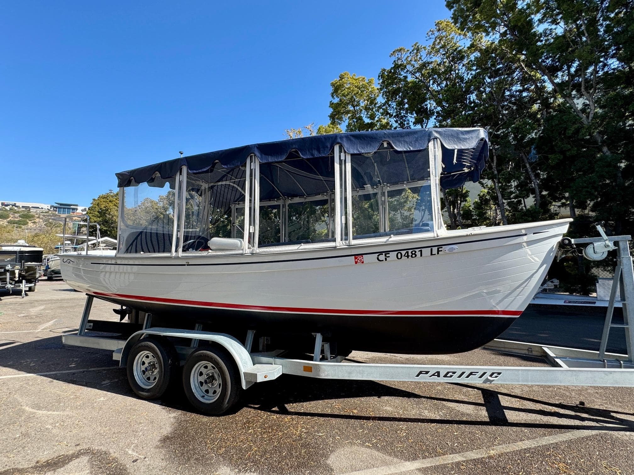 2022 Duffy Sun Cruiser boat on trailer, parked outdoors under clear blue sky.