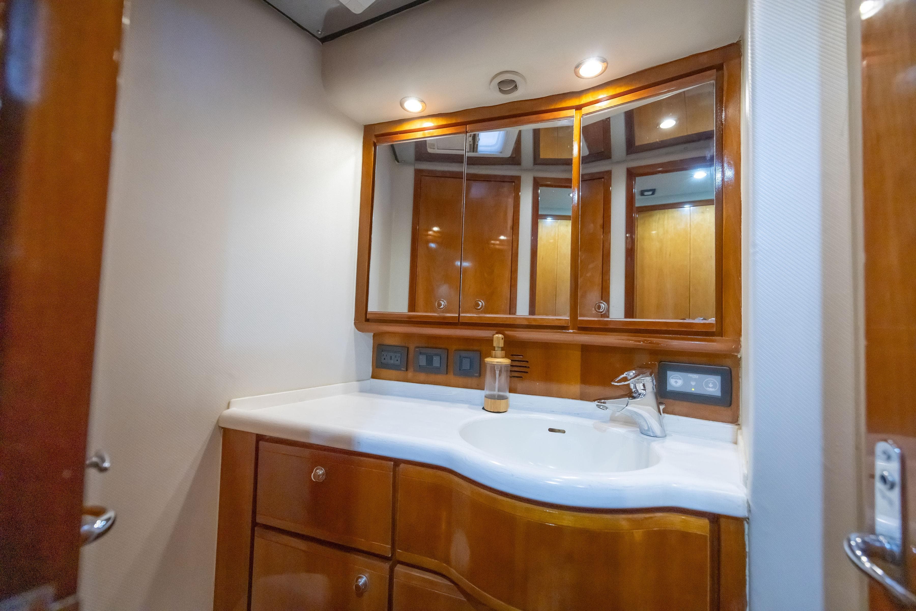 Luxurious bathroom interior of 2009 Bertram 510 yacht with wooden cabinetry and modern fixtures.