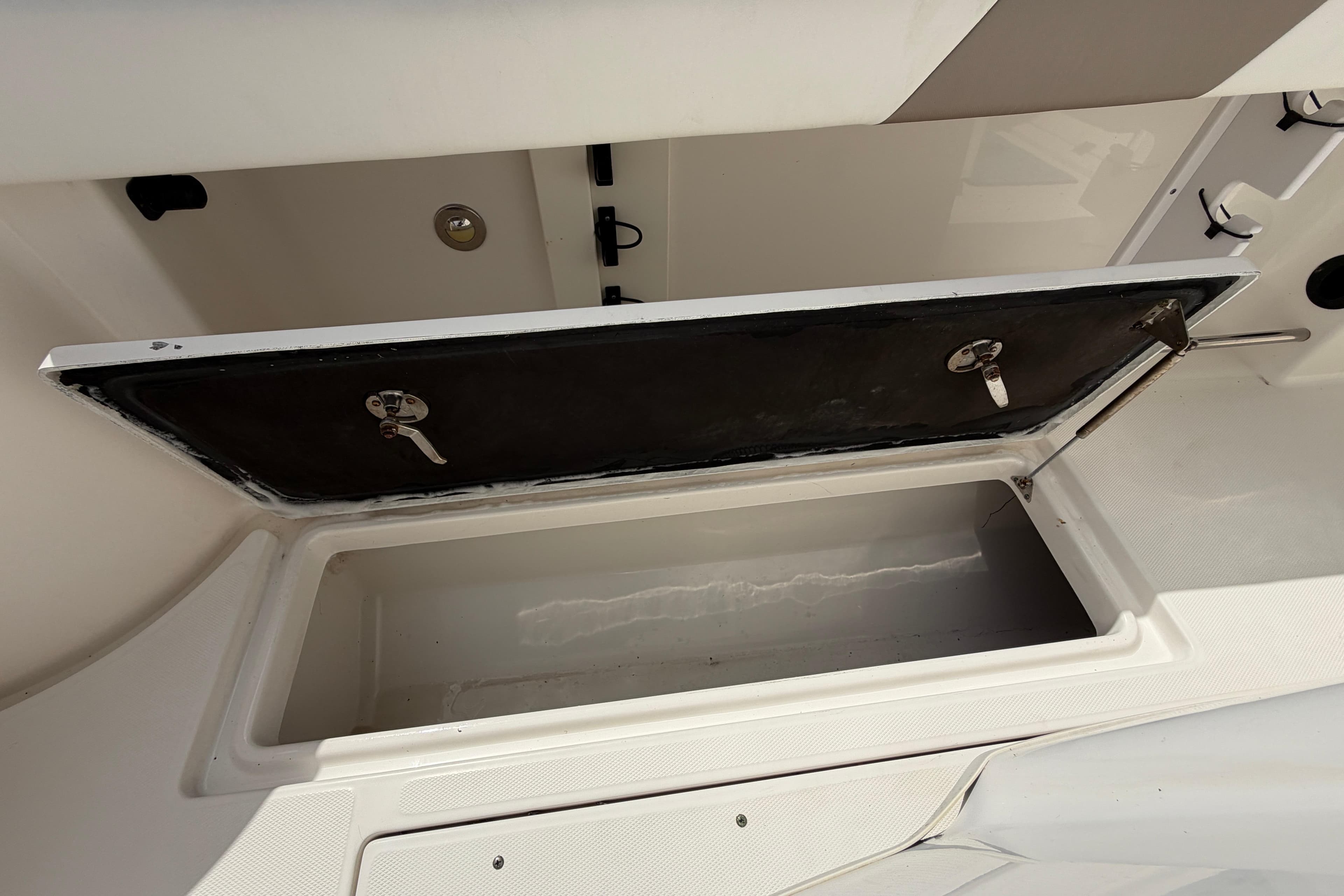 Open storage compartment on a 2015 Robalo R300 Center Console boat.