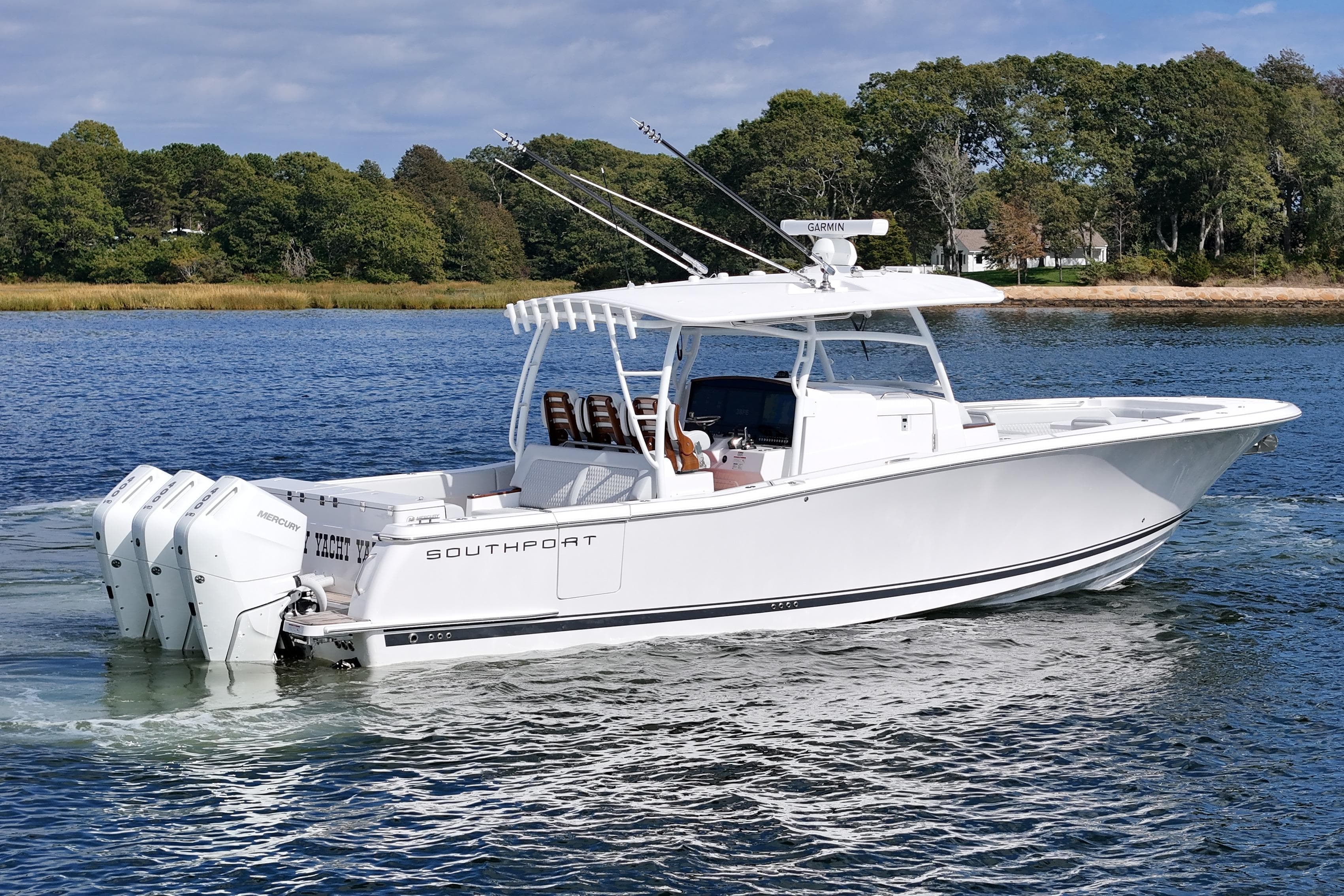 2025 Southport 38 FE boat cruising on a serene lake with lush green shoreline.