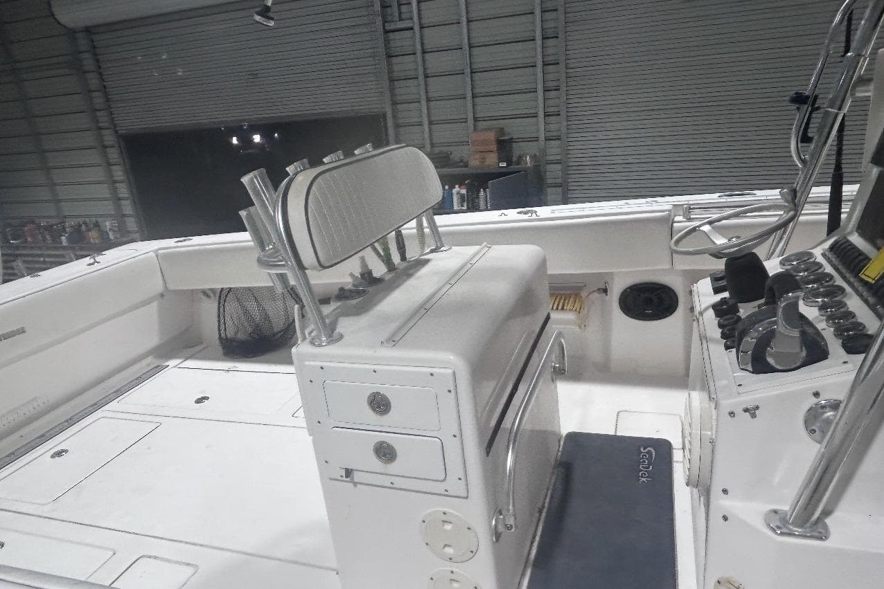 2005 Contender 35 ST boat interior with helm, seating, and storage compartments in a garage.