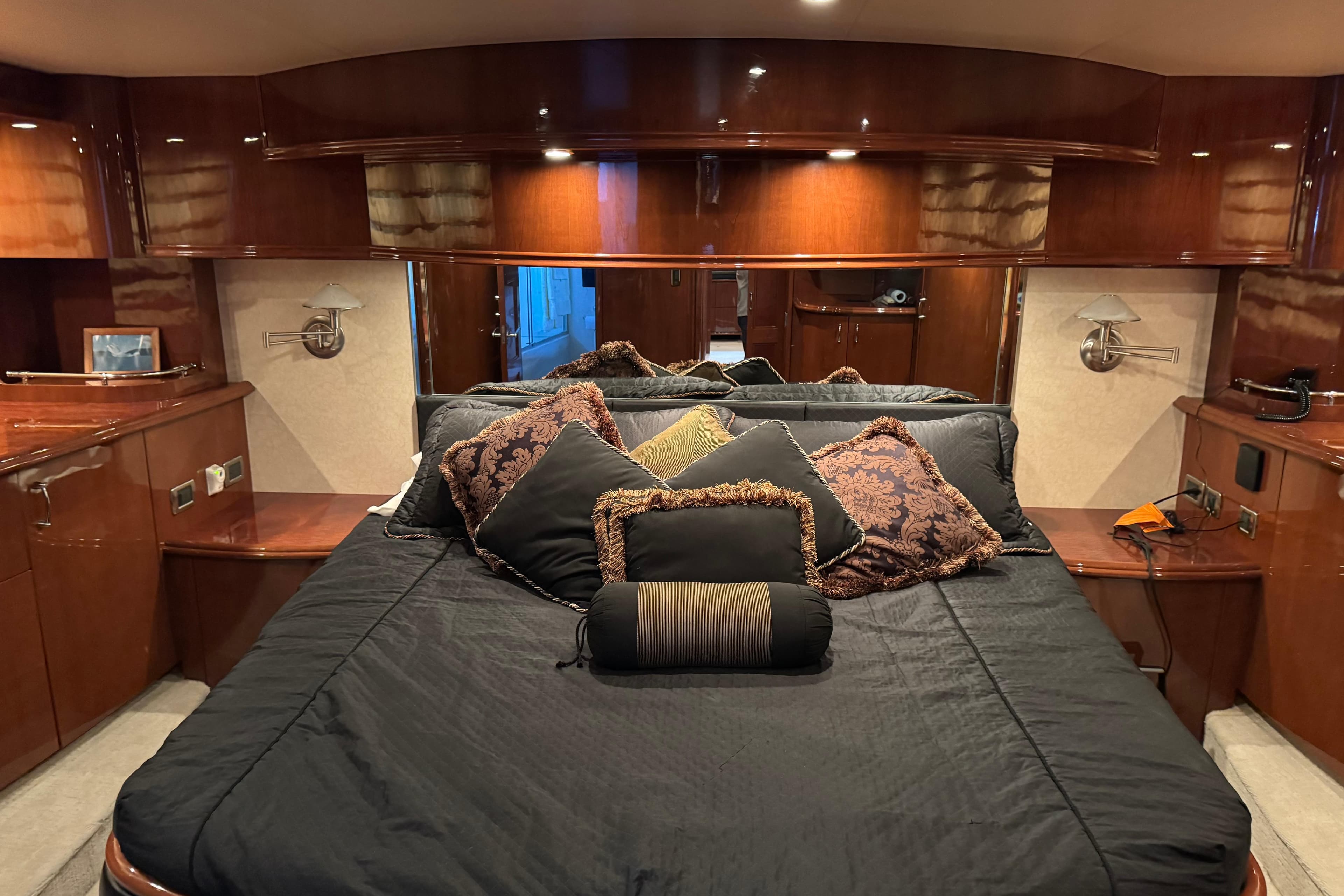 Luxurious 2006 Marquis 59 yacht bedroom with elegant wood finish and plush bedding.