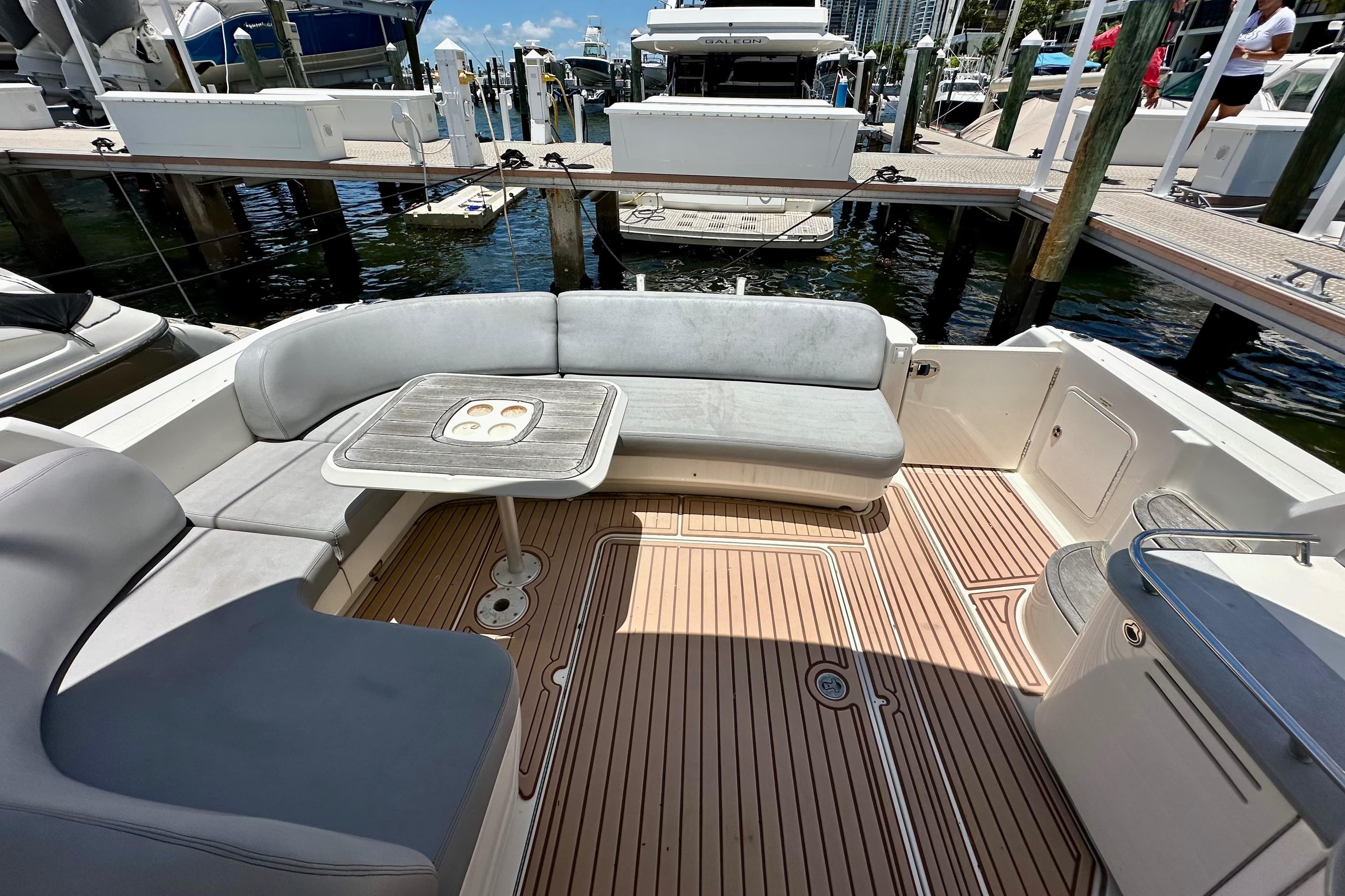 2005 Sea Ray 48 Sundancer yacht with spacious deck seating and table at marina.
