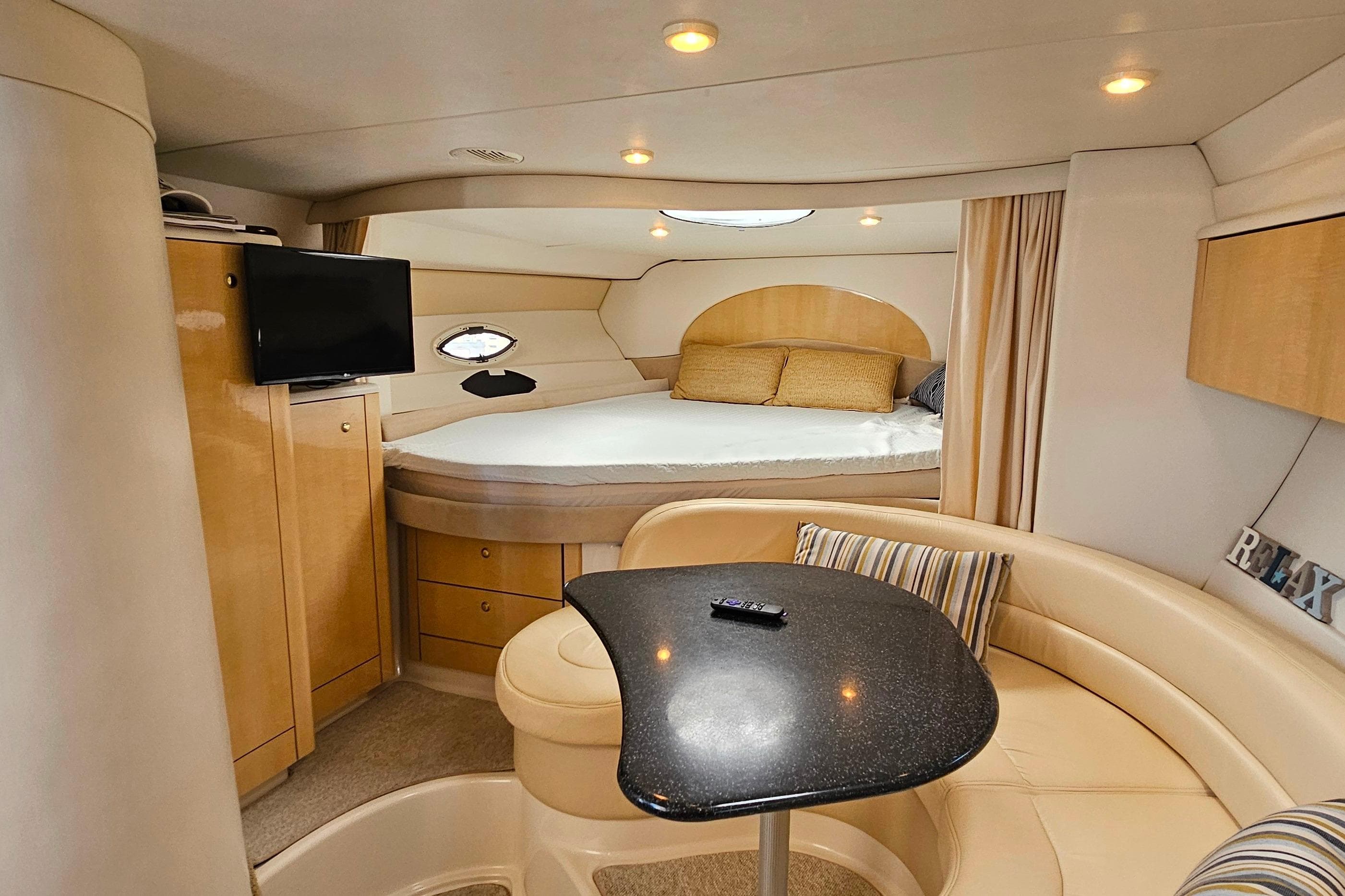 Interior of 2001 Maxum 3500 SCR yacht with cozy seating and bed area.