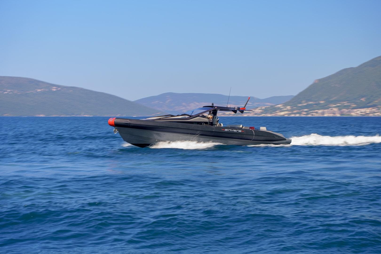 2023 Anvera 48 luxury boat cruising on open sea with scenic mountain backdrop.