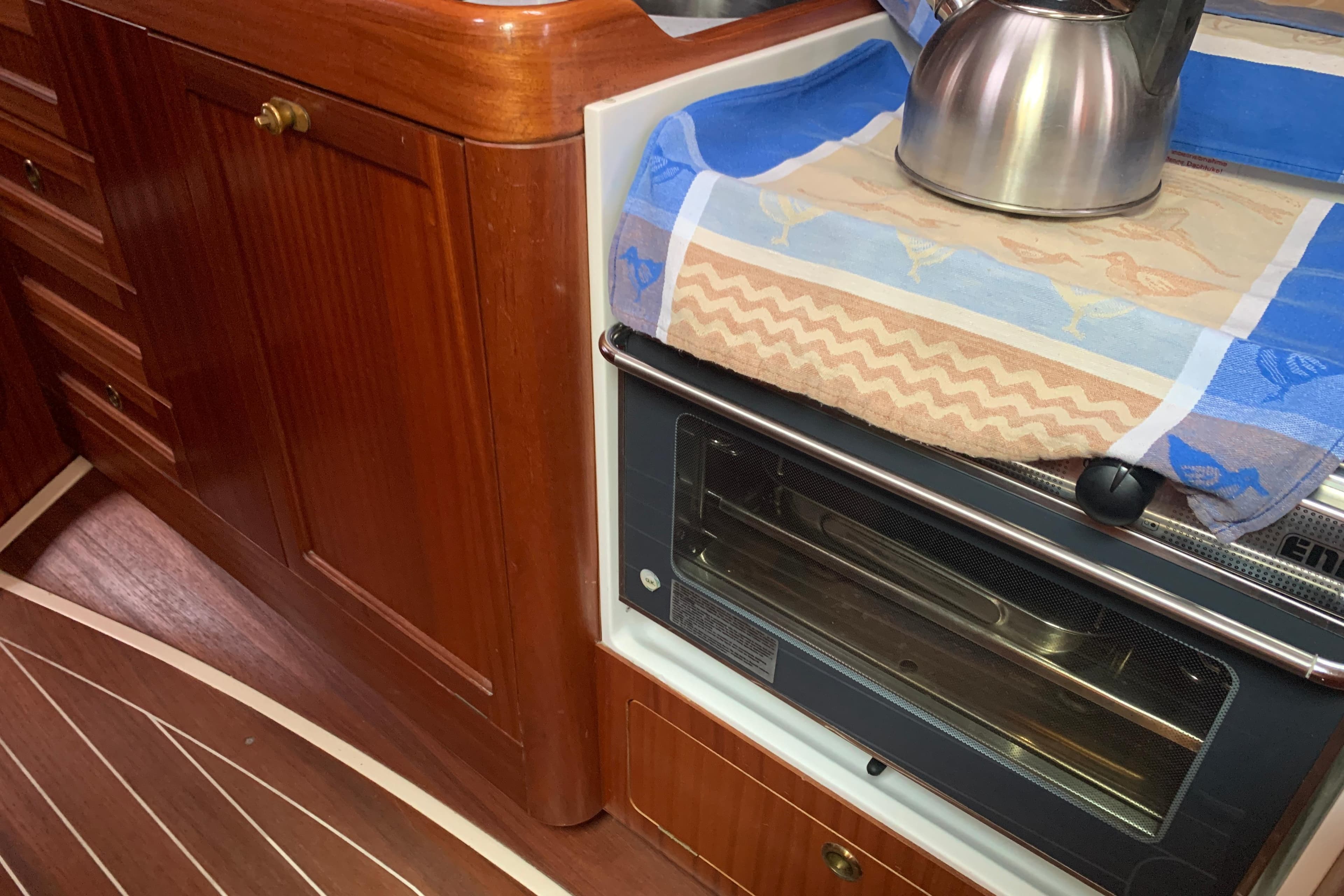 Wooden yacht kitchen interior with stove, kettle, and towel, Sunbeam 37, year 2000.