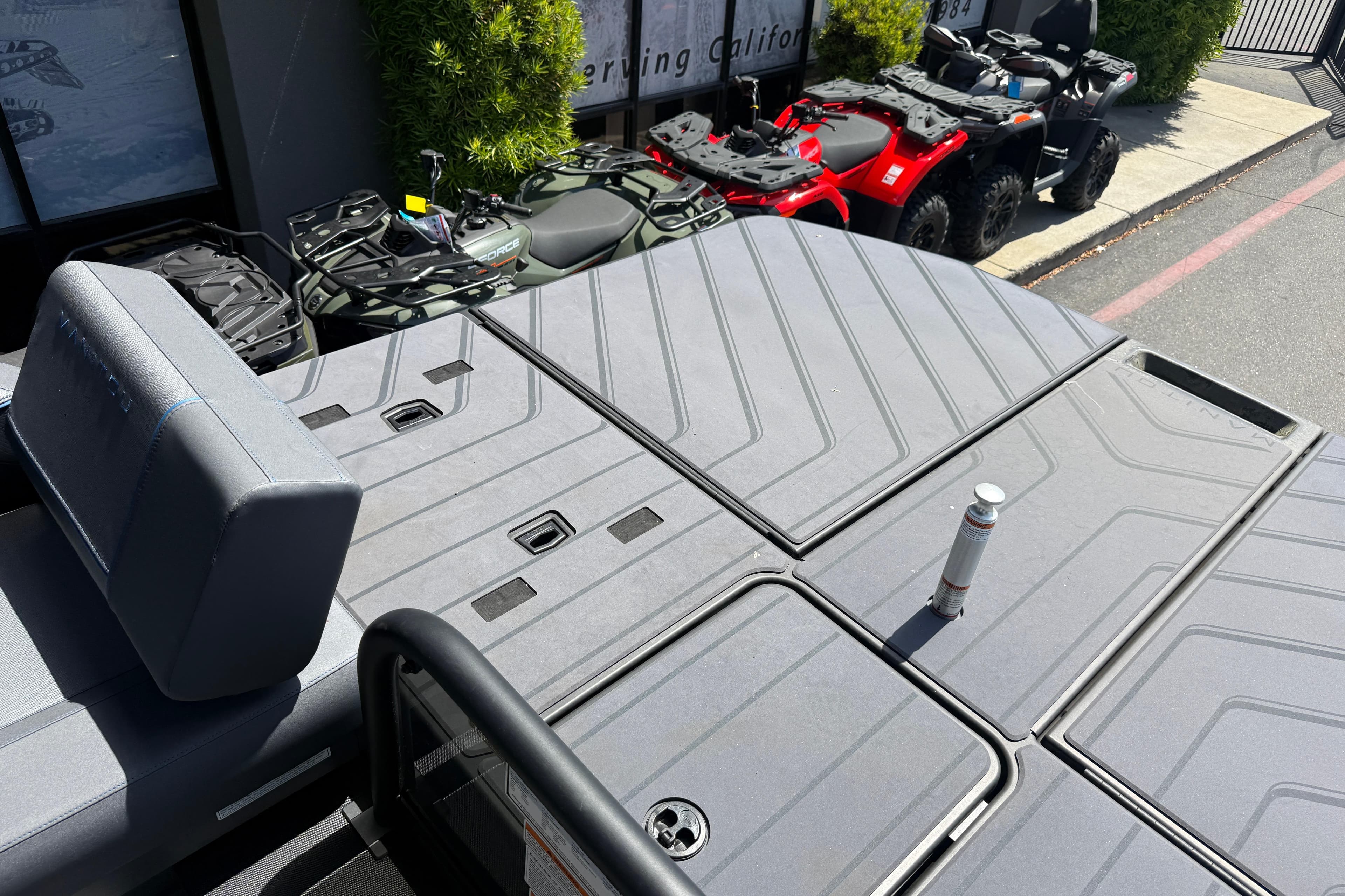 2025 Manitou Explore Dual Engine boat deck with seating and storage compartments.