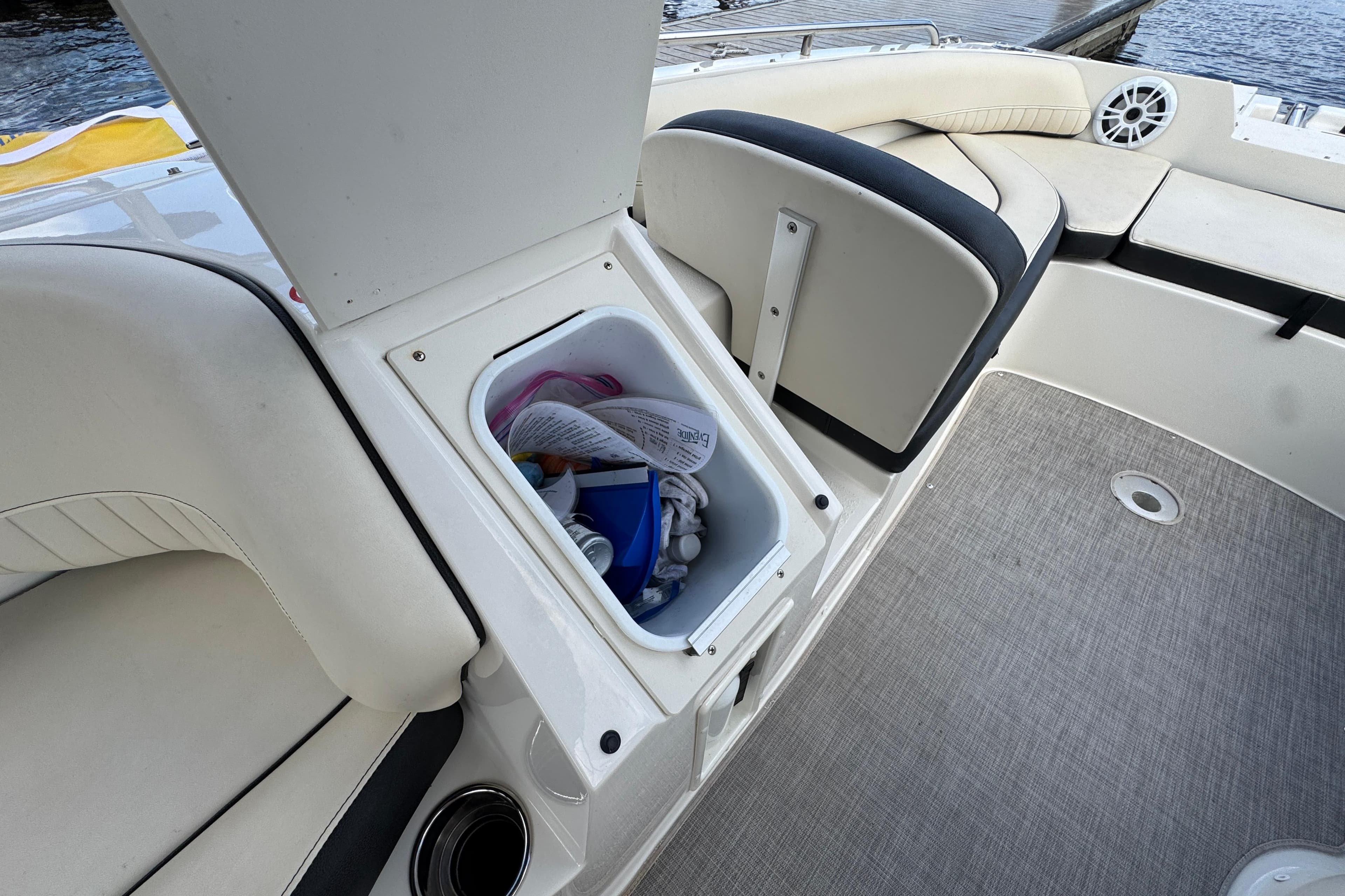 Open storage compartment on 2022 Stingray 192 SC boat, showing interior items and seating area.