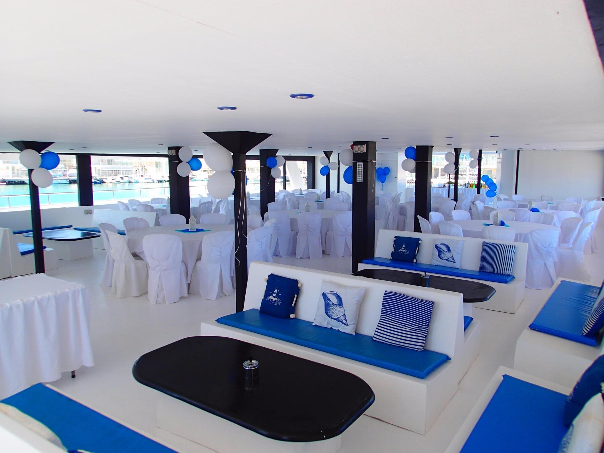 Luxurious 2015 Power Catamaran interior with elegant white and blue seating, perfect for events.