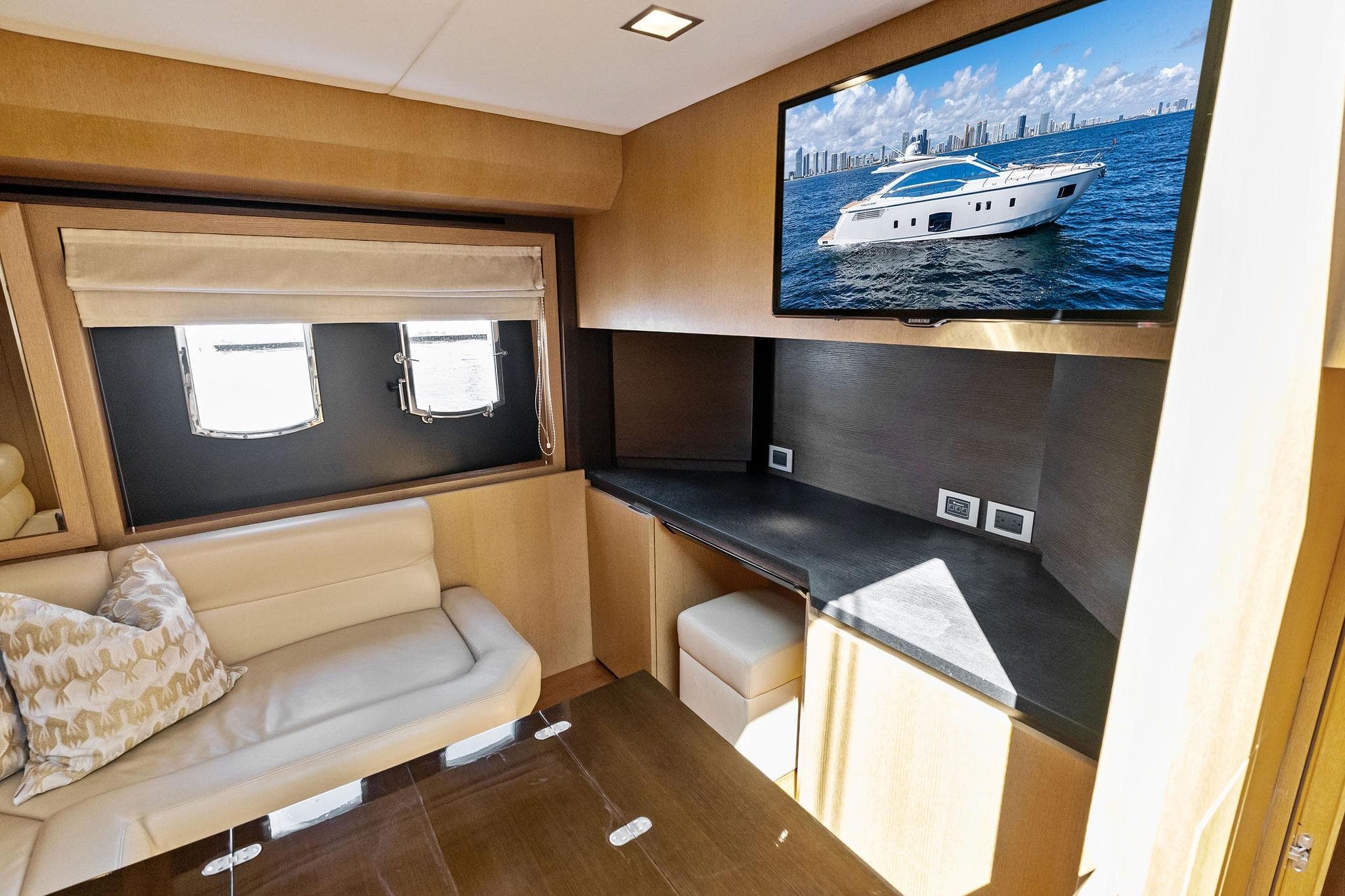 Luxurious interior of 2013 Absolute 64 yacht with sofa, desk, and TV.