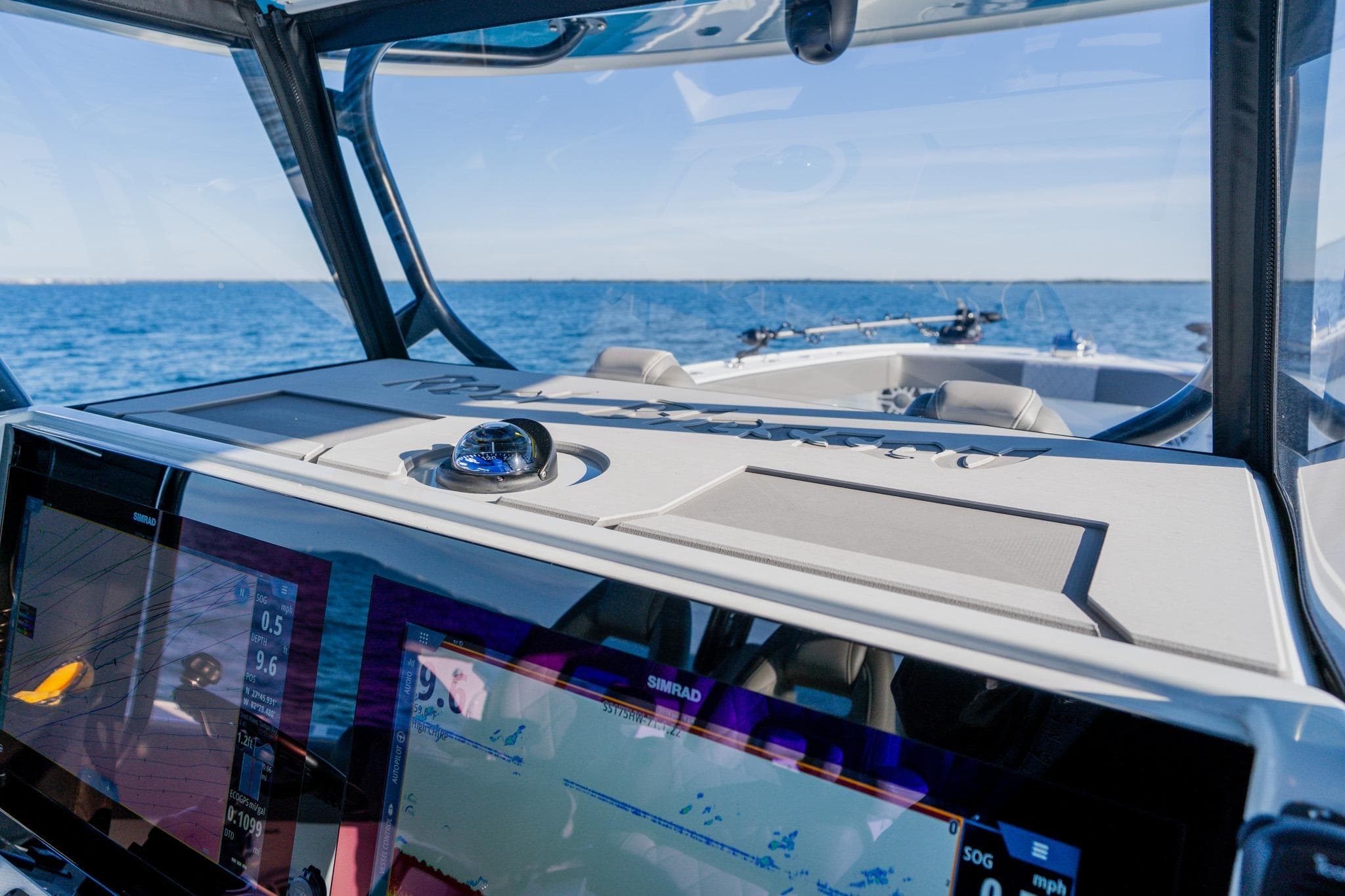 Interior view of 2025 Freeman 42LR boat with navigation screens and ocean backdrop.