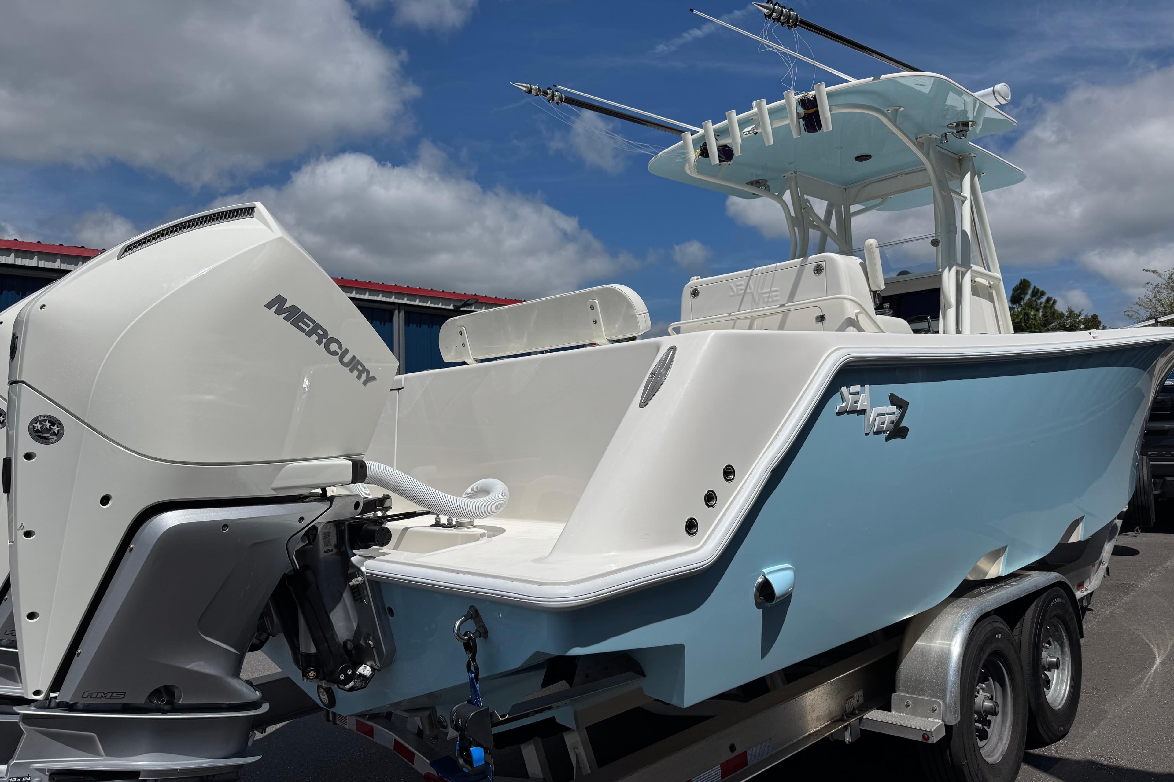2024 SeaVee 32Z boat with Mercury engine on trailer, under a cloudy sky.
