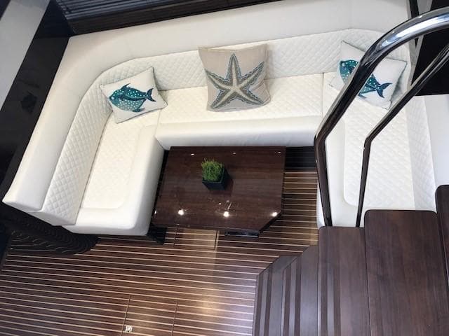 Luxurious interior of 2018 Galeon 485 yacht with white seating and decorative pillows.