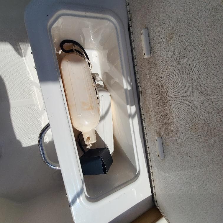 Storage compartment in a 2019 Bayliner VR5 Bowrider OB boat, containing a fender and accessories.