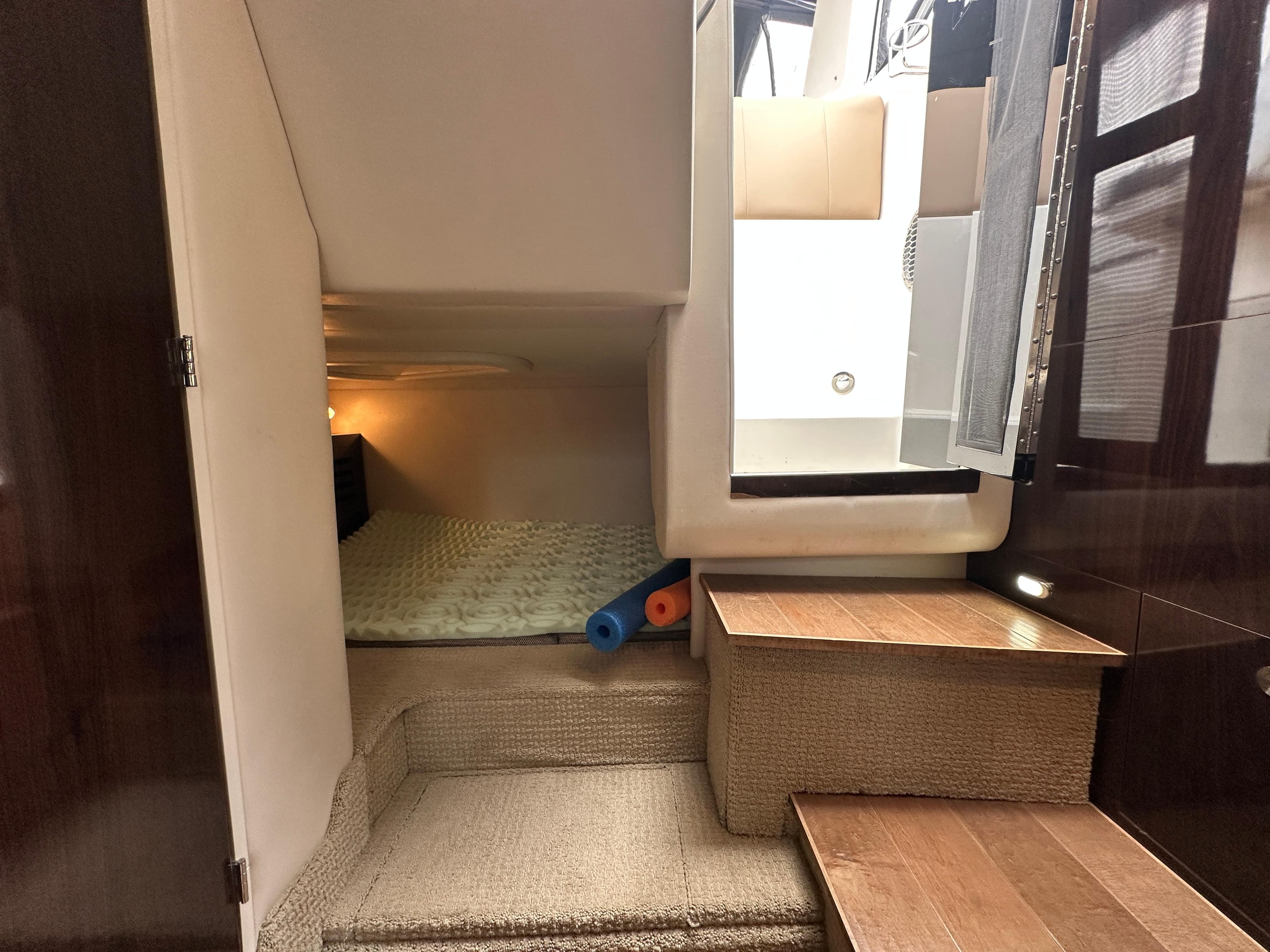 2017 Sea Ray Sundancer 310 cabin interior with cozy sleeping area and wooden steps.